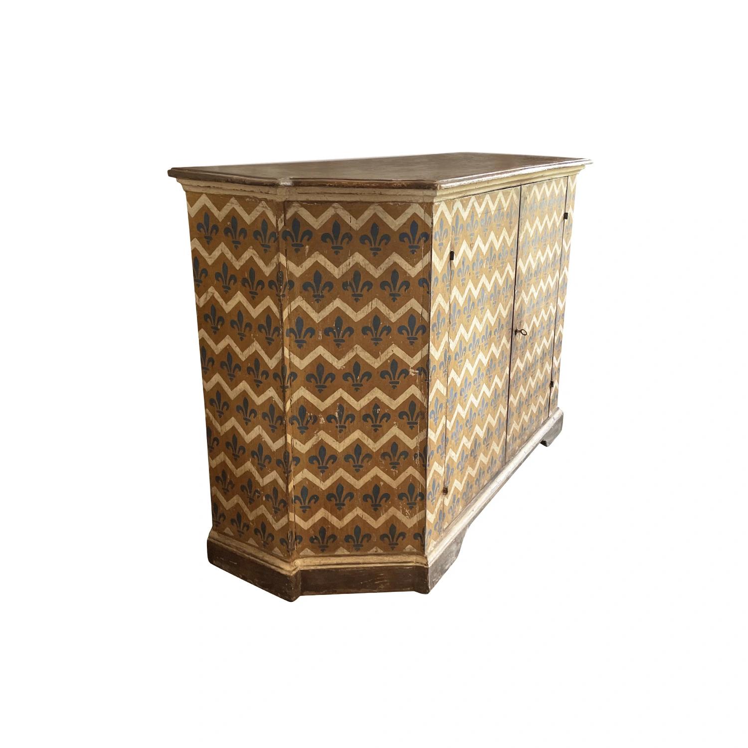 A mid 19th Century Italian buffet in a very interesting geometrical pattern with continuous blue Fleur de Lys and ecru colored zigzag pattern on a golden Sienna colored background. The patinated Florentine commode has a slightly raised rectangular