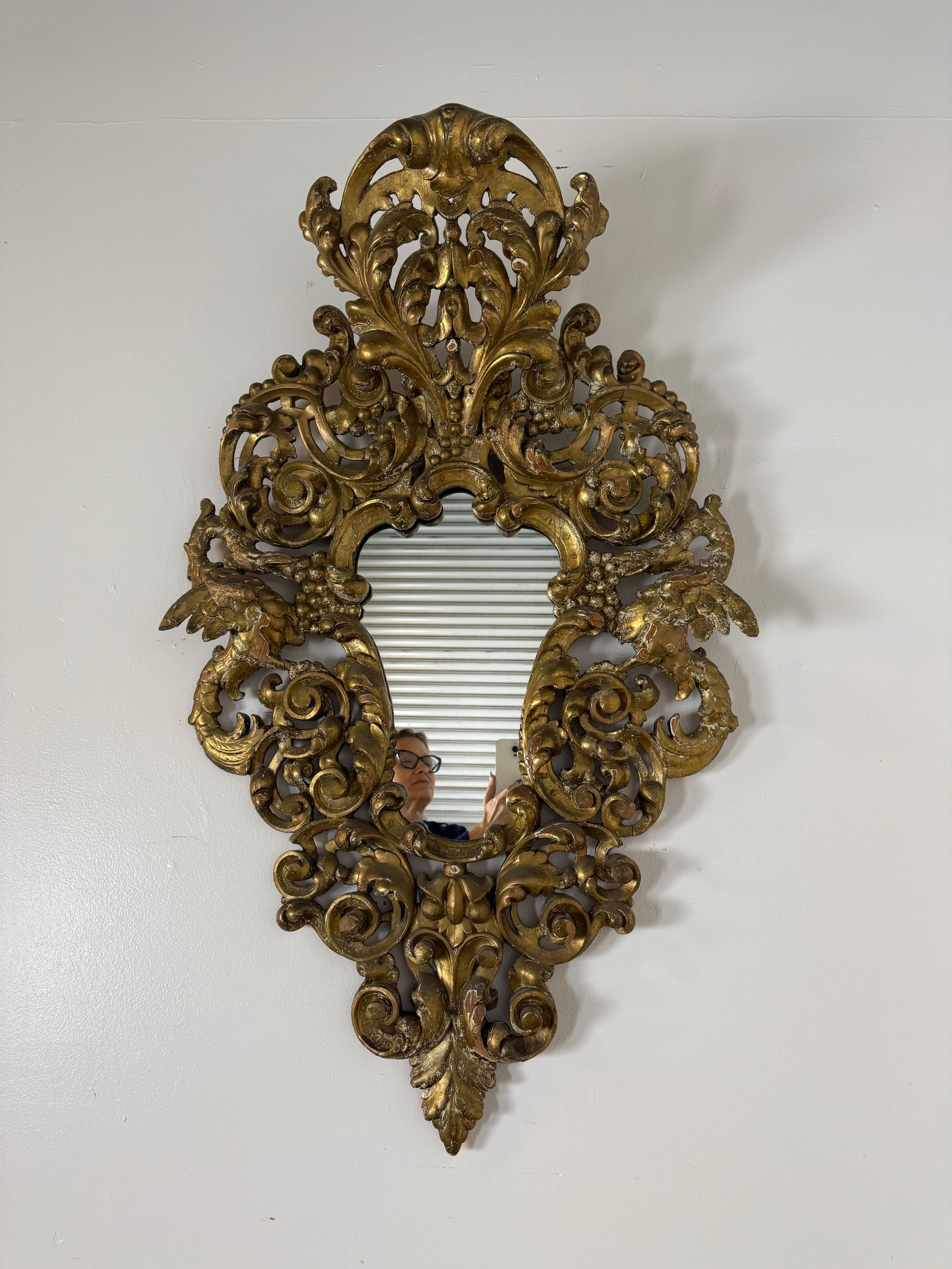 Exubérant miroir italien du XIXe siècle, de style baroque, sculpté et en bois doré, richement décoré de rinceaux feuillagés, de plumes d'acanthe et de sculptures profondément percées. Le cadre est une véritable célébration de l'artisanat italien -