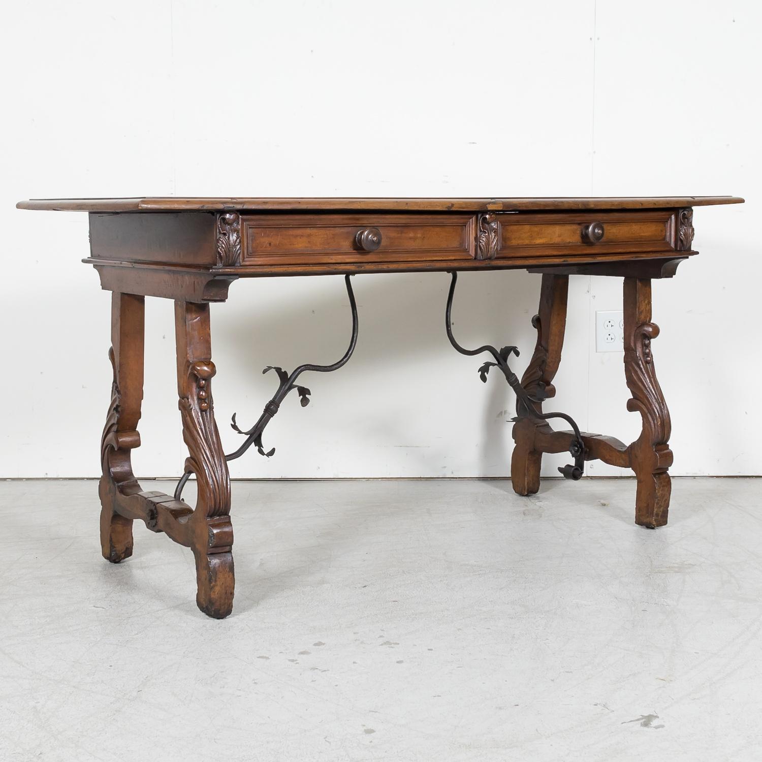 A stunning early 19th century Italian fratino console table handcrafted in the Tuscany region near Florence of solid walnut with intricate details and timeless design, circa 1800. Having a beveled edge rectangular top above a carved frieze featuring