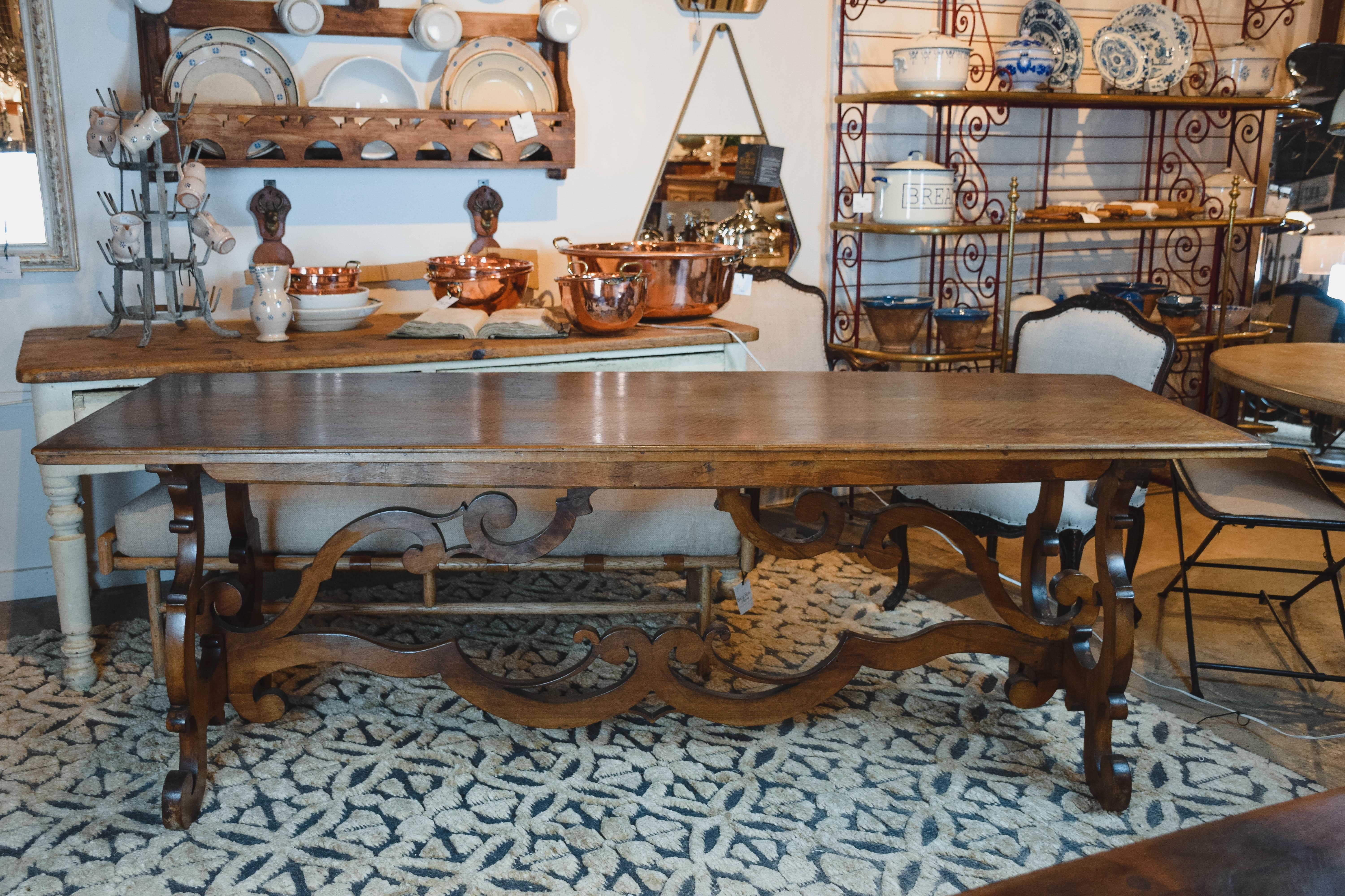 This 19th century Italian Baroque style walnut trestle table handcrafted by artisans in Tuscany has beautiful lyre bases and stretcher. This gorgeous table with its wonderful rich color would seat 10 comfortably, but is also narrow enough to make a