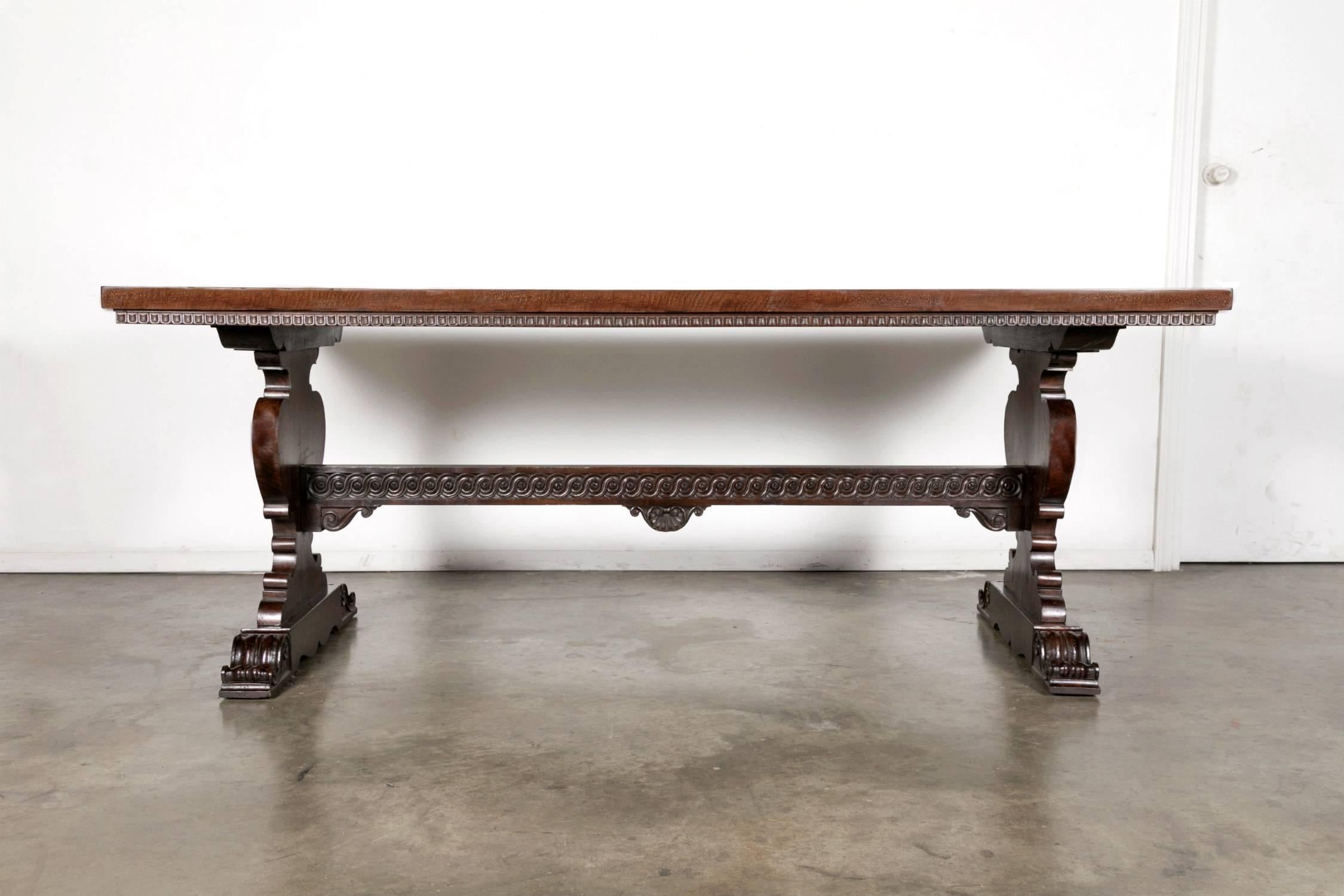 19th century Baroque style trestle table handcrafted of solid walnut by talented artisans near Florence, Italy. This very handsome Tuscany table has a rectangular top with a fruitwood marquetry band and carved molded border. Raised by intricately