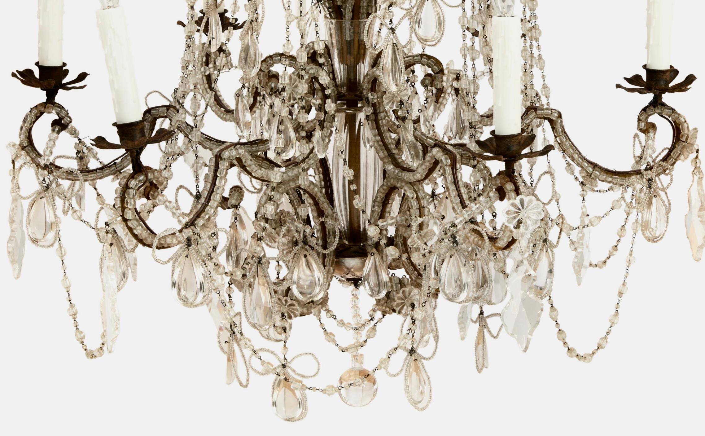 Gran e impresionante araña italiana de cuentas y cristal del siglo XIX con seis (6) luces. La preciosa base curvada está cubierta de cuentas entre una multitud de prismas colgantes, algunos en forma de trébol con lazos y cintas de cuentas por todas