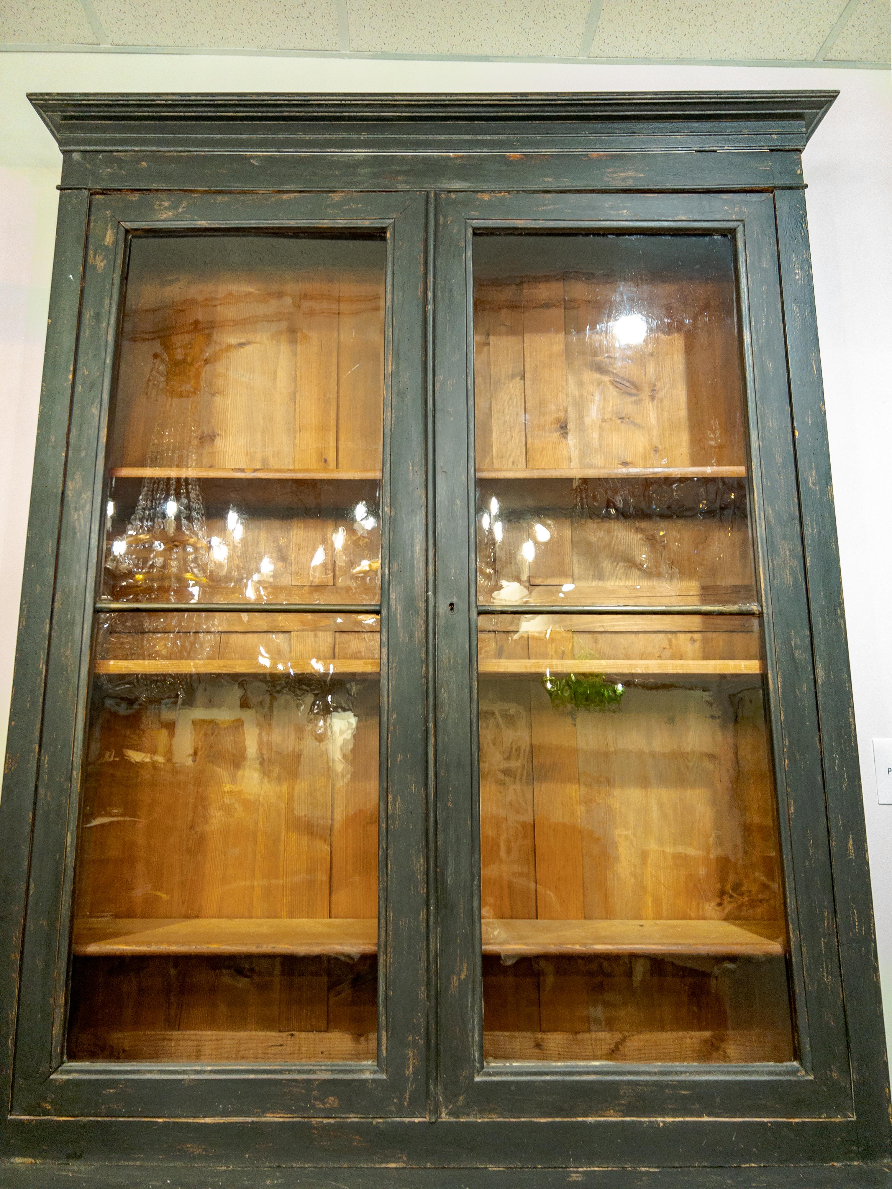Italienische Bibliothek aus dem 19. Jahrhundert aus bemaltem Holz mit schönen gewellten Glas-/Verglasungstüren und 3 beweglichen Regalen im Inneren. Darunter befinden sich 2 getäfelte Türen mit 1 Einlegeboden, so dass insgesamt 4 Einlegeböden in