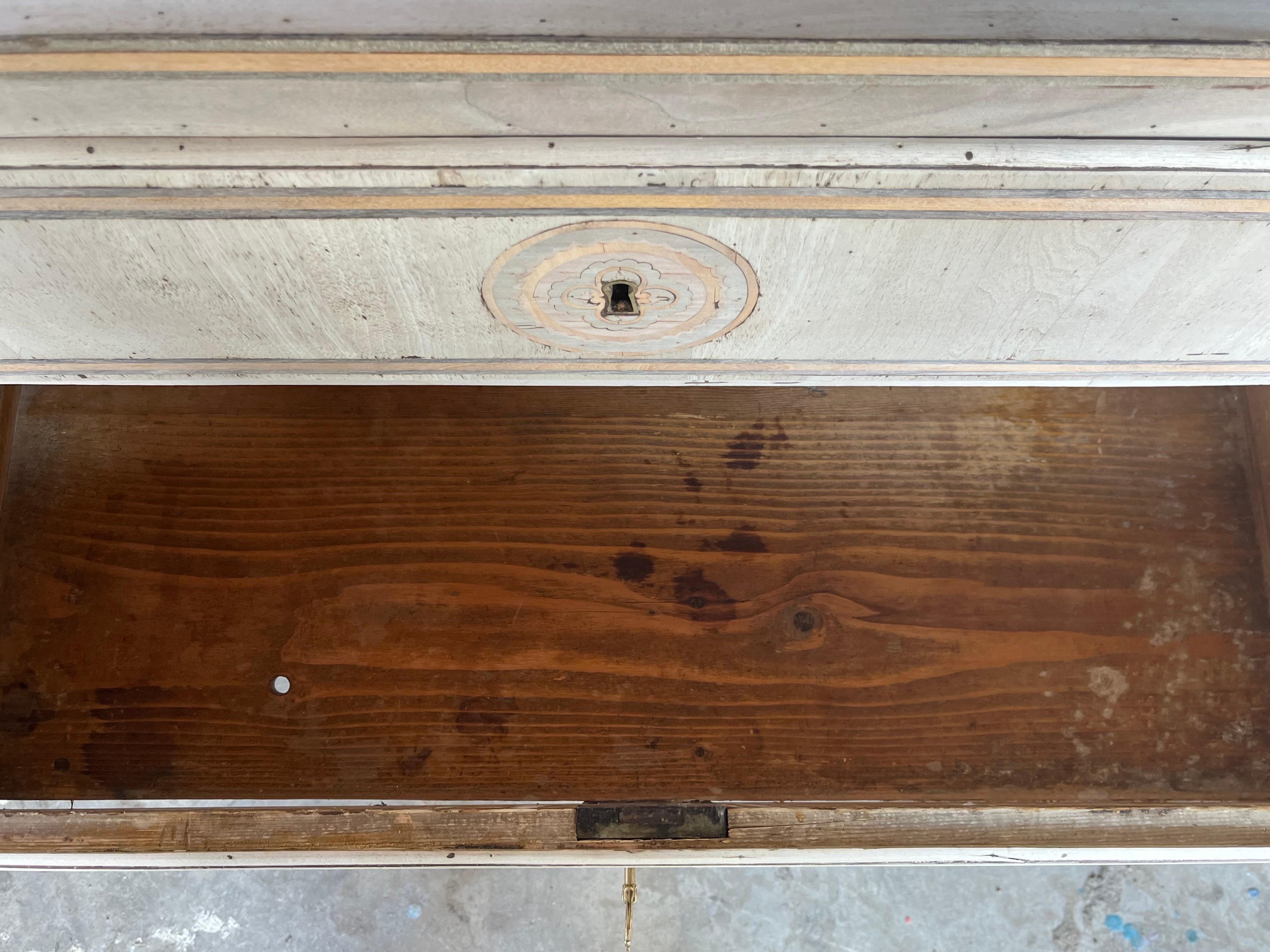 Neoclassical commode hand-made in Italy in the mid 1900s using walnut and decorated with walnut veneer. The commode is very straight in lines and features two overlay drawers with ogee edges and flat drawer fronts. along the edge of the drawer