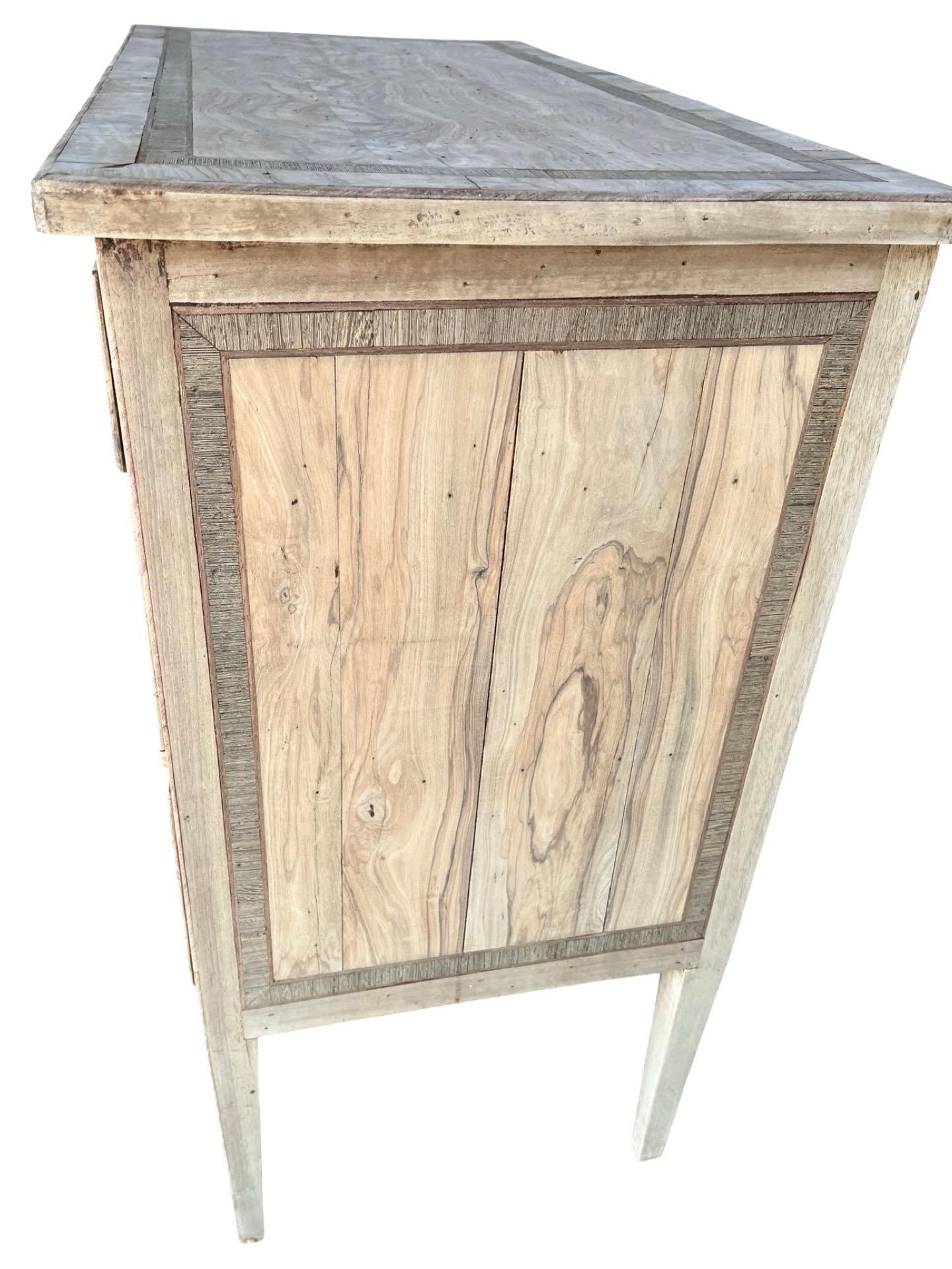 Comò neoclassico realizzato a mano in Italia all'inizio dell'Ottocento con legno di noce e decorato con impiallacciatura di noce. La commode presenta due cassetti più piccoli su due più grandi, tutti dotati di splendidi incastri a coda di rondine