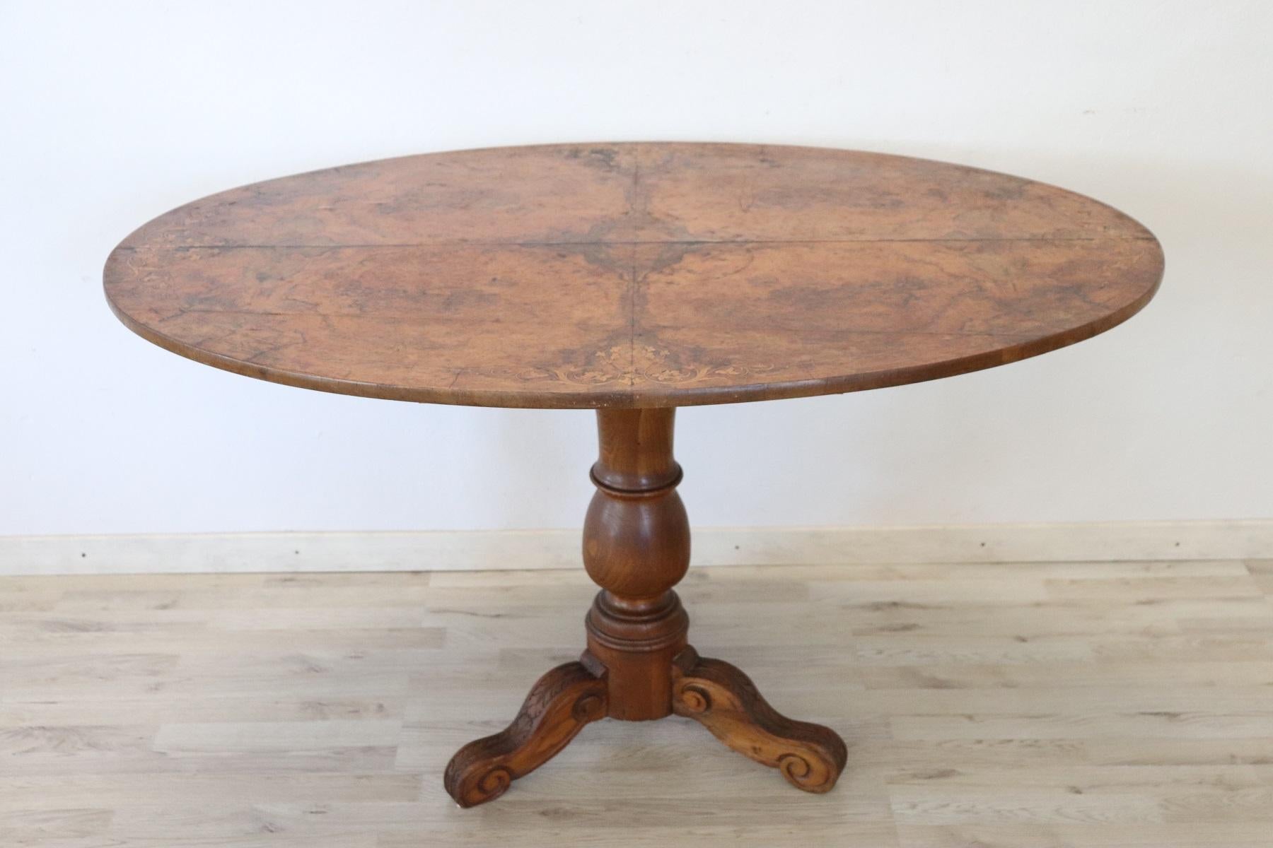 Beautiful important antique oval table, 1850s in walnut. The plan presents precious work of inlay and briar root. The inlaid decoration is of floral taste made with small pieces of different and precious woods. Please look at all the images to