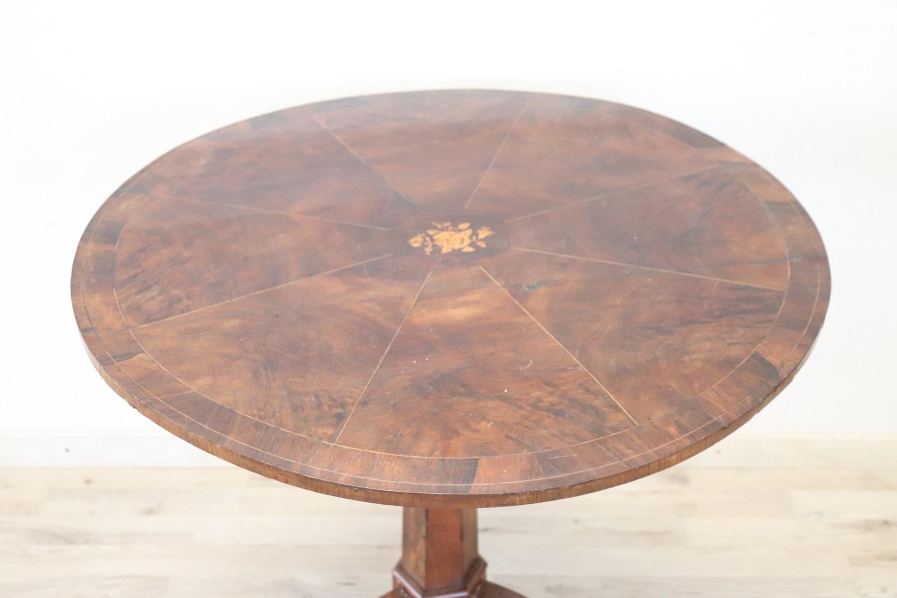 Beautiful important antique round table, 1850s in walnut. The plan presents decorations in wedges with a beautiful inlaid rose in the center. The inlaid decoration is of floral taste made with small pieces of different and precious woods. Please