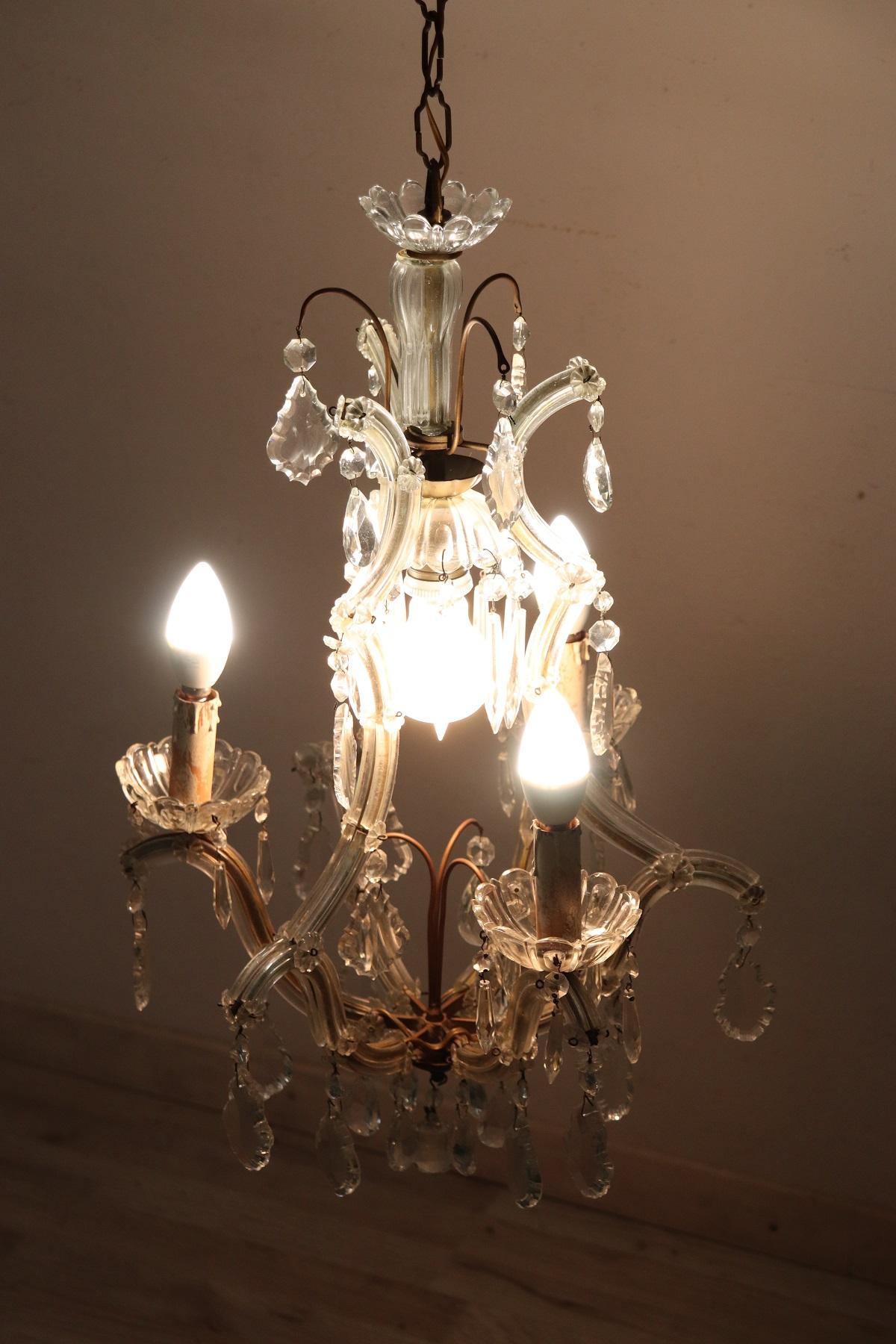 Beautiful and refined Italian circa 1880s chandelier four lights. In bronze and completely covered drops of crystal. The crystal exudes the typical brightness; the drops are finely worked giving an elegant light. Chandelier of refined elegance and