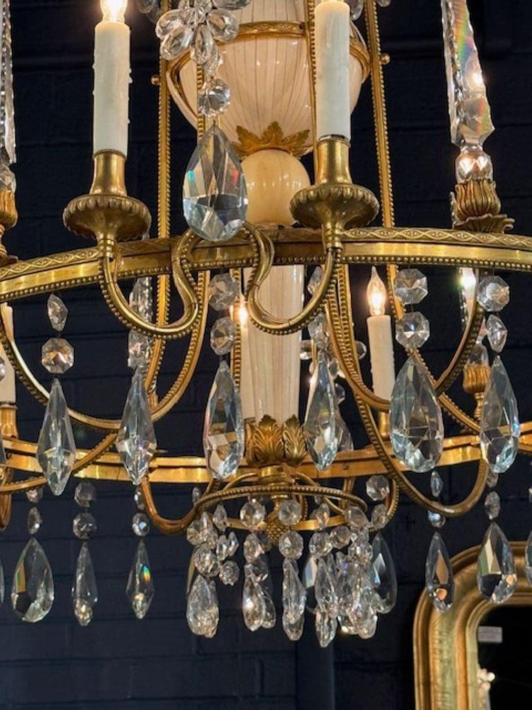 Experience the elegance of the 19th century with this exquisite Italian bronze and crystal chandelier with bones accents on the base. The chandelier's bronze framework is intricate and detailed, showcasing exceptional craftsmanship adorned with
