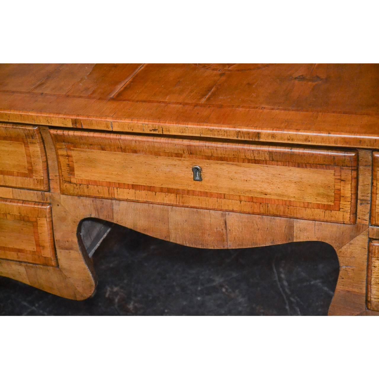 Outstanding 19th century Italian burl walnut and satinwood banded writing desk with old rich patina. The top and sides inlaid with star-like design inlays. The knee-hole nicely contoured and fitted with five drawers. The entire on sleek and graceful