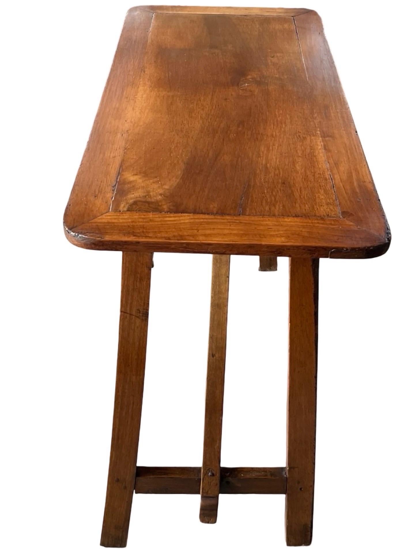 Small capretta table hand-made in Italy in the early 1900s using walnut and pegged construction. The table is tall and thin, making it perfect as a side table or end table, but also as a little entry table against a wall, where to place a nice