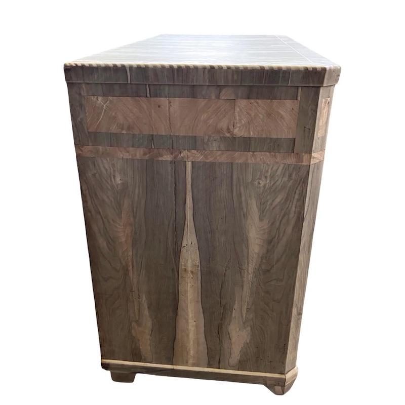 Chest of drawers hand-made in Italy in the early 1800s using walnut and decorated with book-matched walnut veneer. The dresser has very straight lines and modern look, despite being more than 200 years old. The chest of drawers features four inset