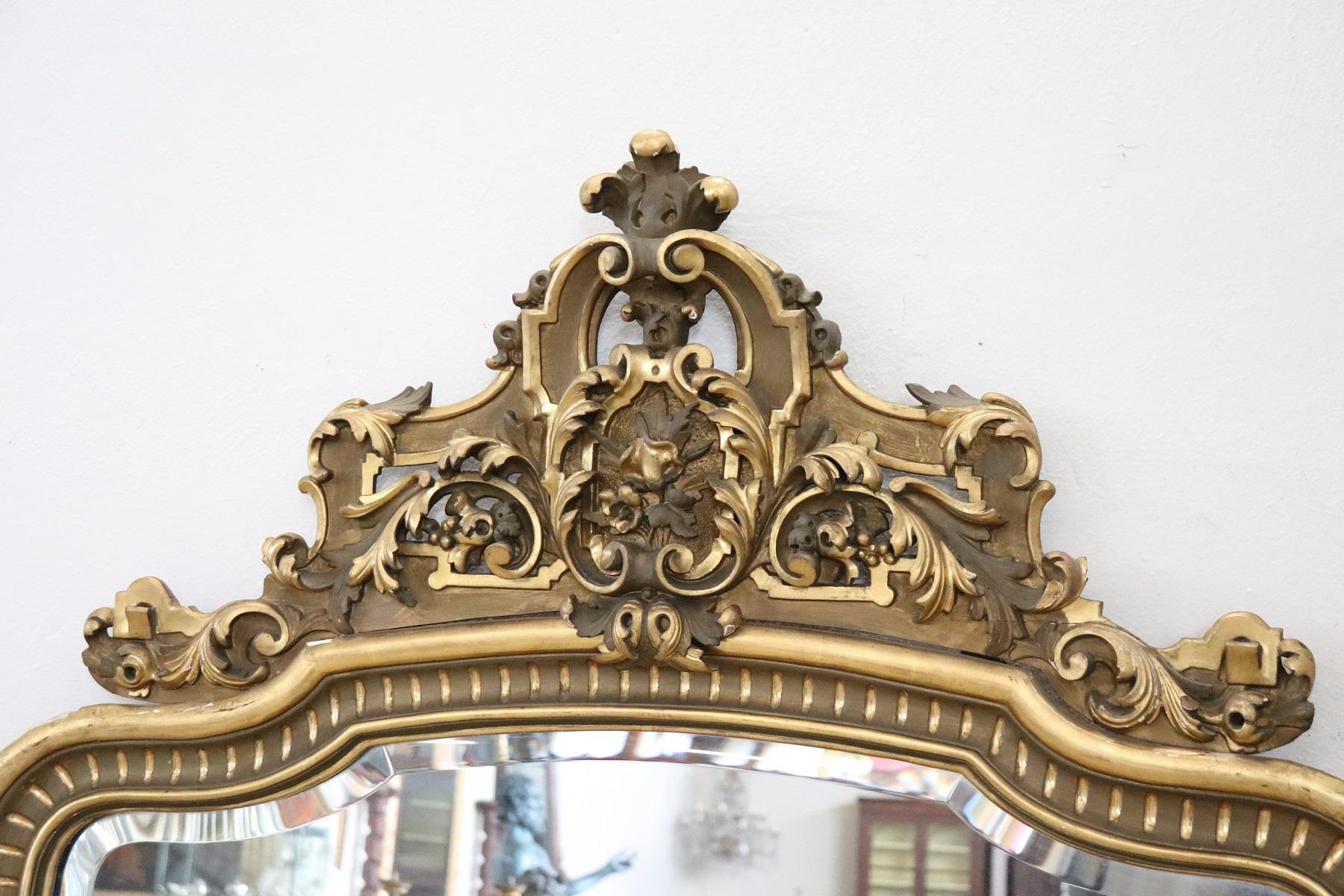 Elegant 19th century Italian carved and gilded wood wall mirror 1850s with refined decoration carving. In the upper part refined lacoro with high artistic quality. Used, good conditions. Elegant in every room of your home. For its large size it is