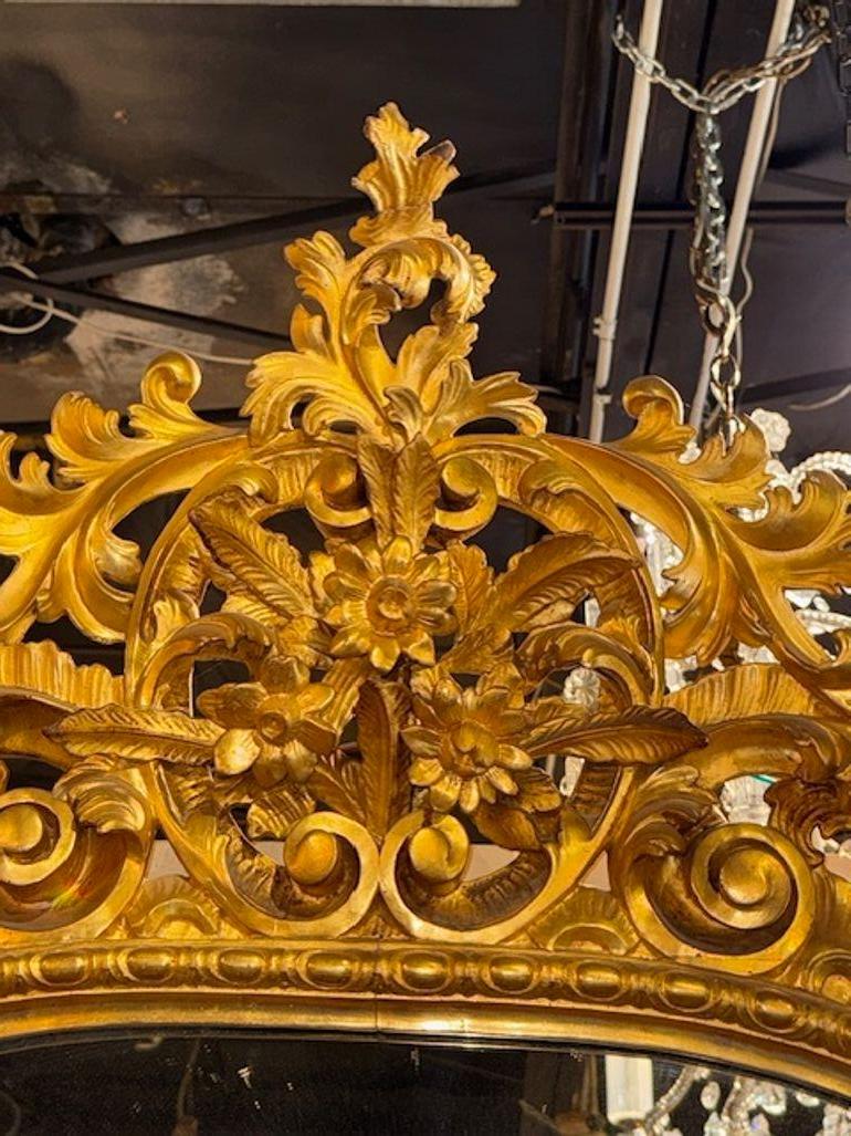 Ce miroir Florentine italien du XIXe siècle, sculpté et en bois doré, est une pièce exceptionnelle aux détails luxueux et complexes. Le cadre sculpté et en bois doré met en valeur le savoir-faire et la sophistication du design italien du XIXe