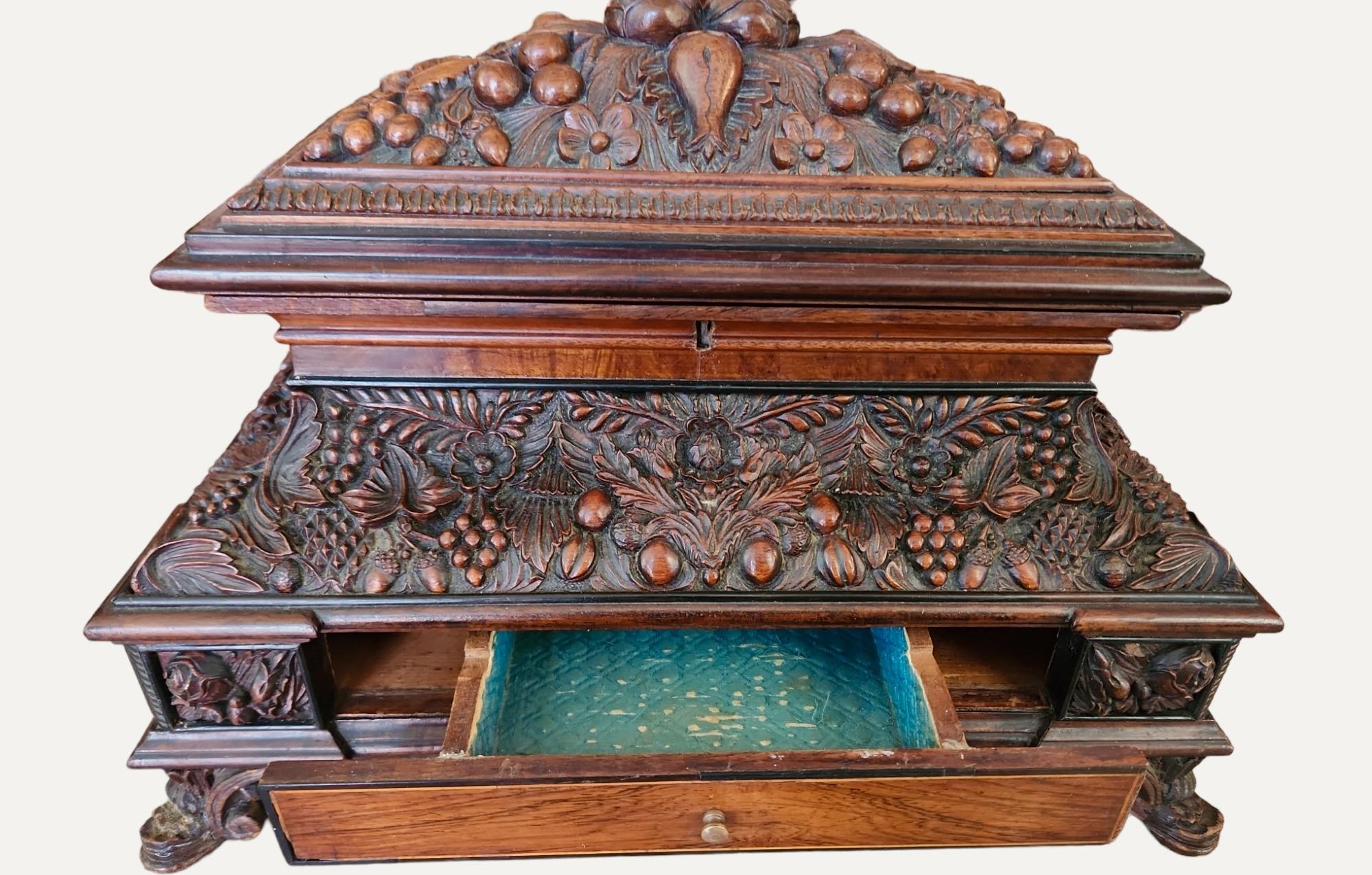 Heavily and finely carved with leaves and fruit,   Has four drawers with inlaid interior.  Could possibly be French.