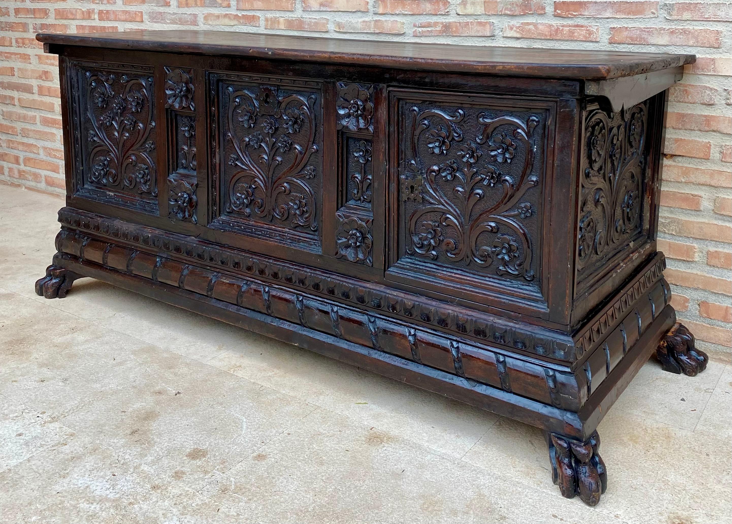 Place this elegant antique coffer at the foot of a king size bed. Crafted in Italy, circa 1880, the rectangular trunk stands on bracket feet. Heavily carved on all three sides with arch and foliage decor, the cabinet features carved panels on the