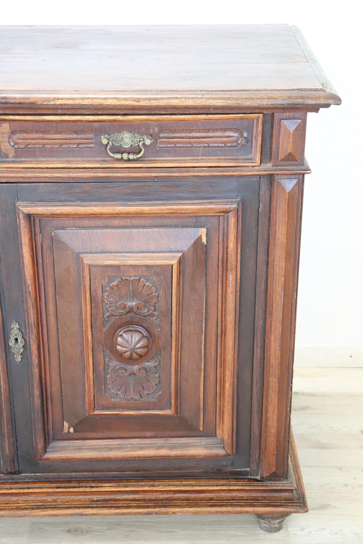 Beautiful antique sideboard featuring carved chestnut wood. On the front doors with carved panels with shell motifs. The two drawers have handles in finely chiseled gilded bronze. Its small size is an advantage because it can also be inserted in