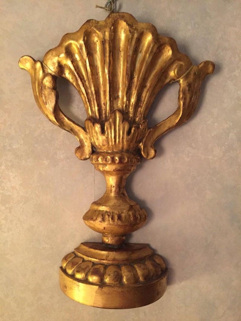 An original hand-carved and leaf gilded wall frieze as a giltwood porta Palme vase with handles.
It comes from a private residence of Milan, where it was topped with a wall demilune lampshade with wiring and it was hanged as an original wall light.