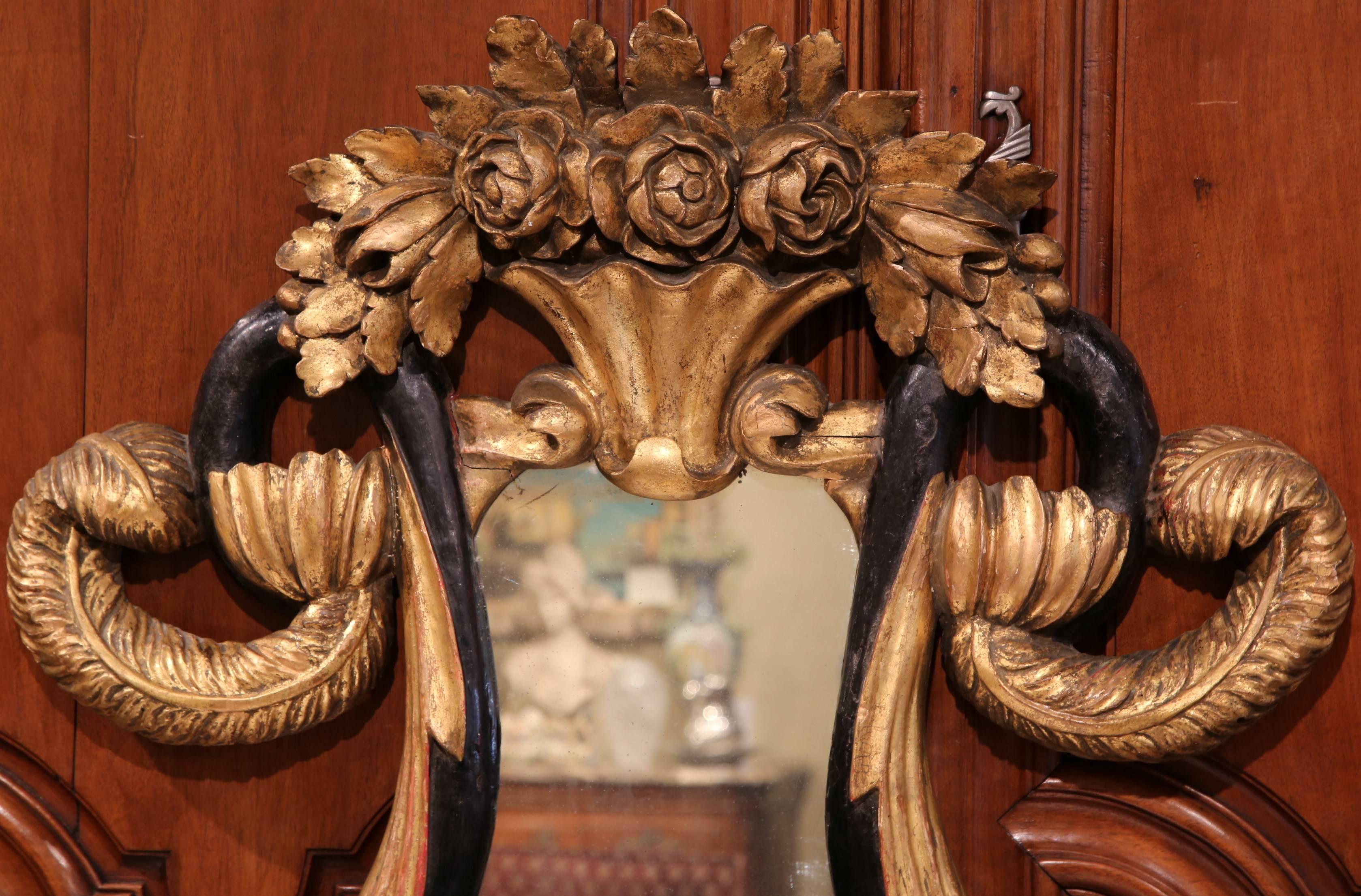 Decorate an entryway, a bedroom, or a powder room with this elegant antique Baroque wall mirror. Crafted in Italy, circa 1860, the mirror is punctuated by a heavily carved pediment of blooming flowers, expressive scrolls and Classic acanthus leaf