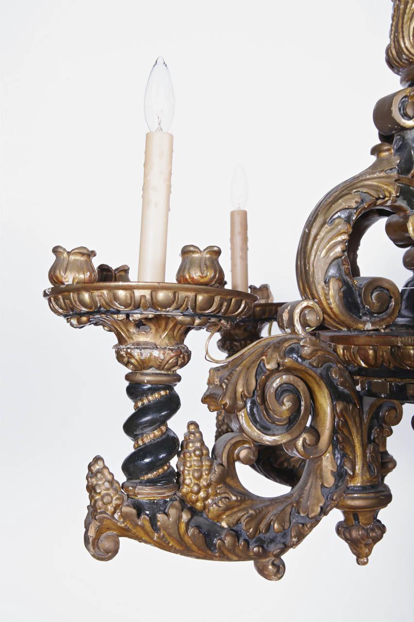 Decorate a breakfast room or entry with this elegant antique chandelier. Crafted in Italy, circa 1870, the piece has heavily carved scrolled motifs and features five arms around a carved central crown. The fixture has new wiring and dressed with wax