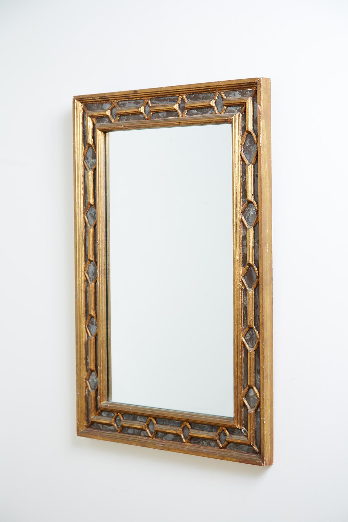 Distinctive 19th century Italian carved giltwood mirror featuring a double carved frame. The frames of the mirror are reeded and showcase a diamond pattern design over antique mirror glass that has a beautifully mottled finish. Centre plate has been