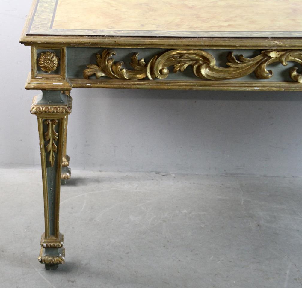 19th century Italian neoclassical carved green gilt and painted foyer table with faux-marble top. Highly decorative with foliate and scroll carvings and fluted legs. Banded faux pink/peach marble top probably added later.