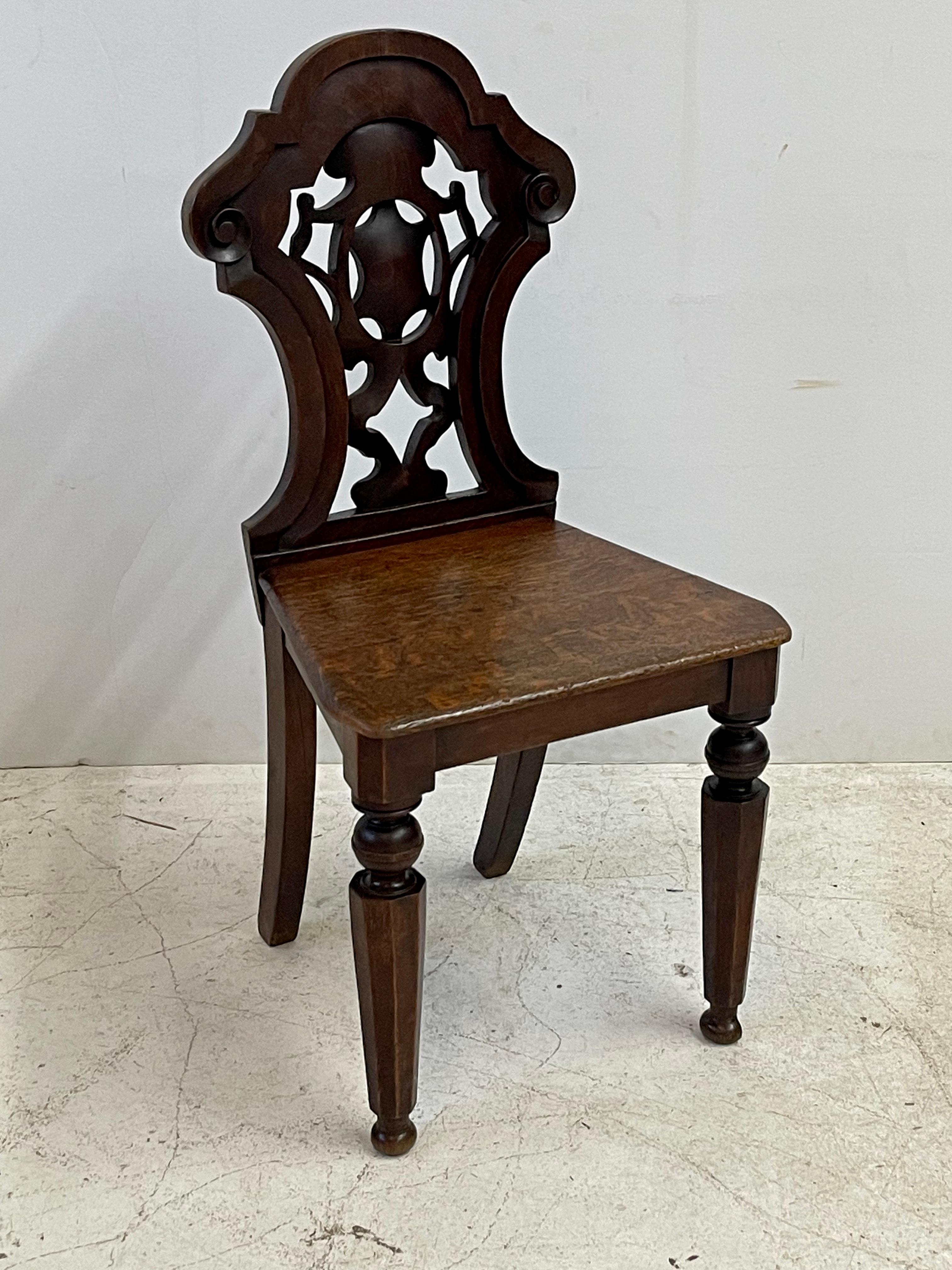 19th century Italian hall chair of oak with a carved and pierced shield back, solid oak seat, and beautifully turned front legs.