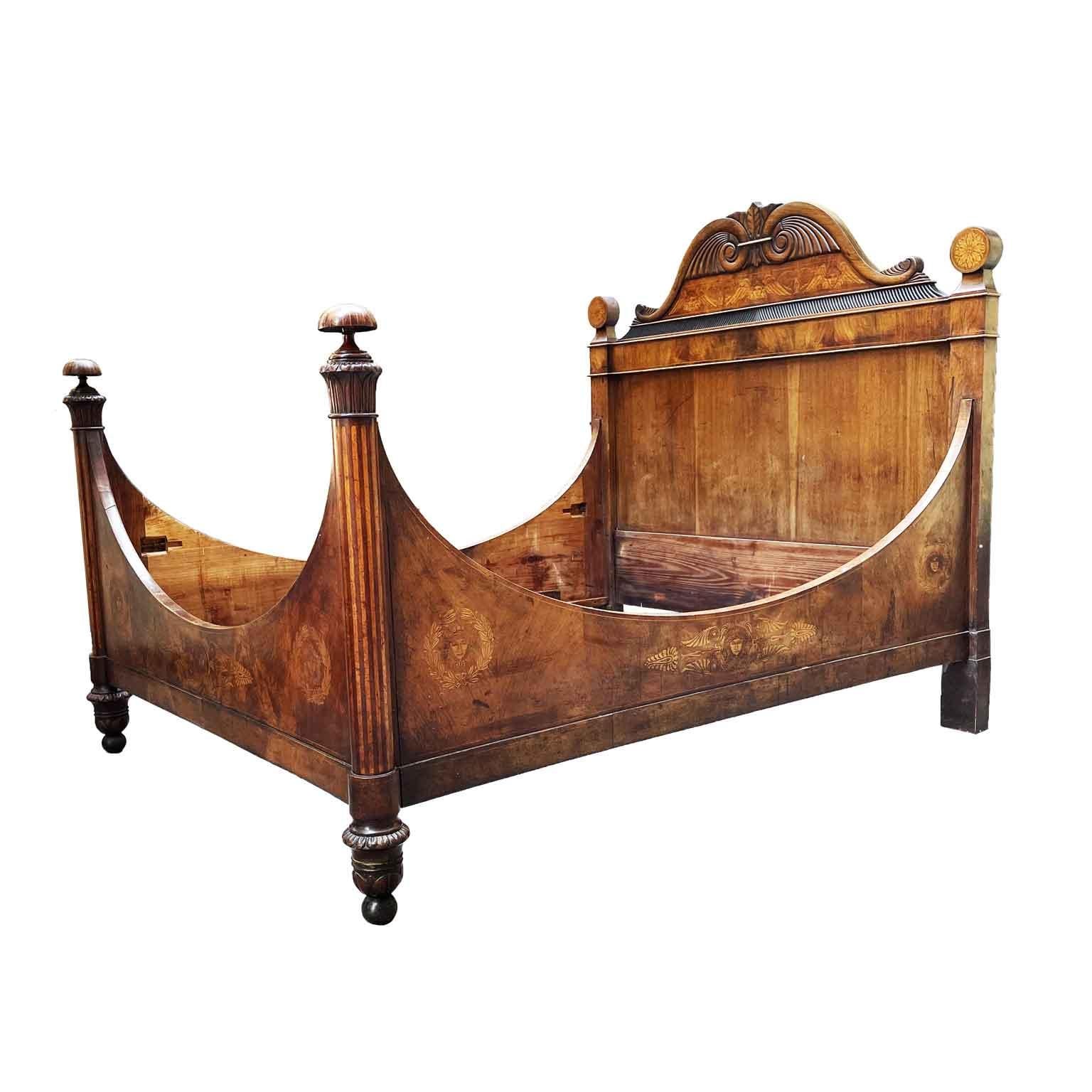 Italian carved walnut double bed dating back to the first half of 19th century, in good condition, with a great original patina. The elegant and unique bed frame is walnut veneer and decorated with masks within laurel frames and palmette decorations