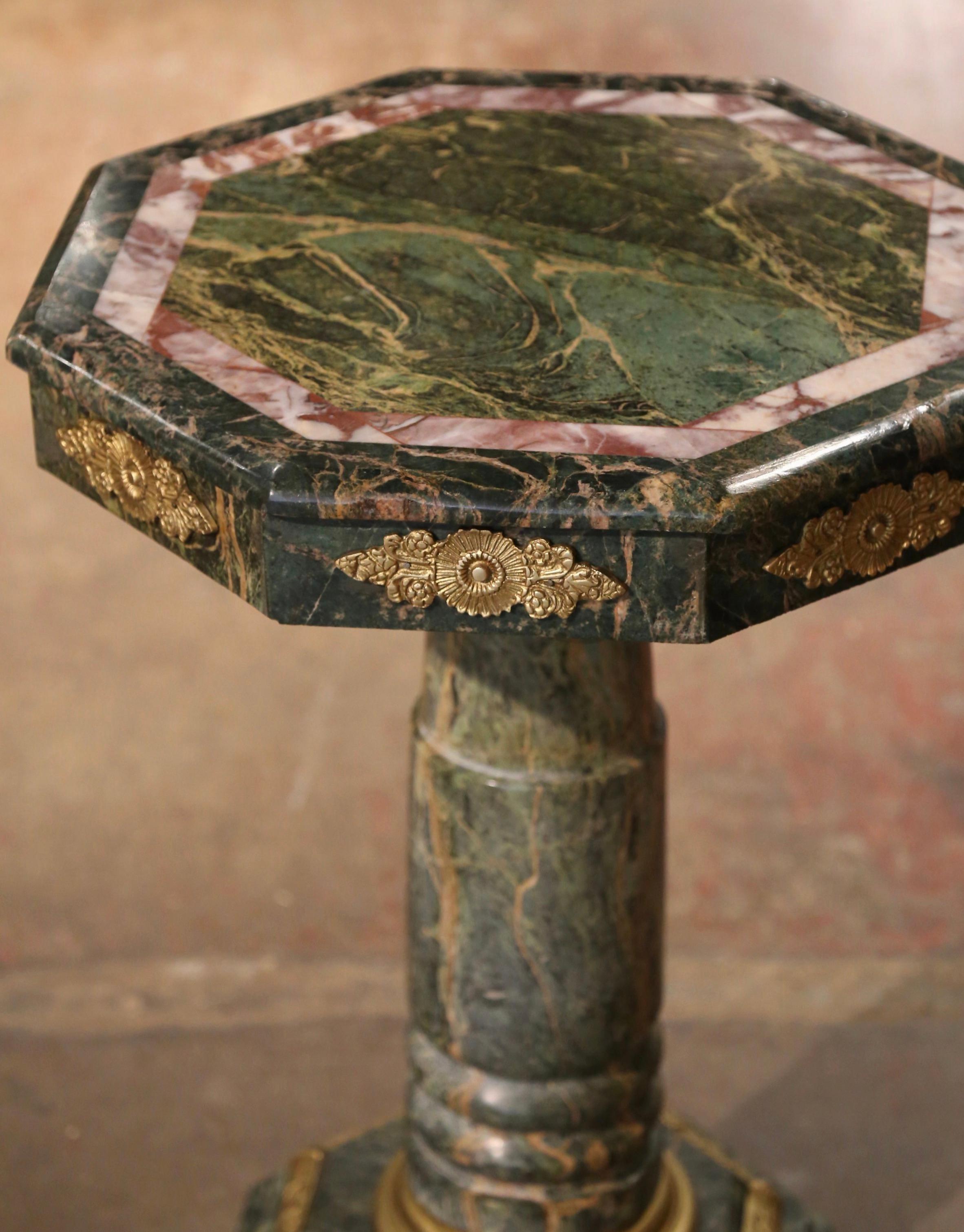 This elegant and colorful antique marble pedestal table was created in Italy, circa 1890. The heavy, sturdy pedestal sits on an octagonal base decorated with brass mounts over a carved round stem embellished with a decorative brass rim at the neck
