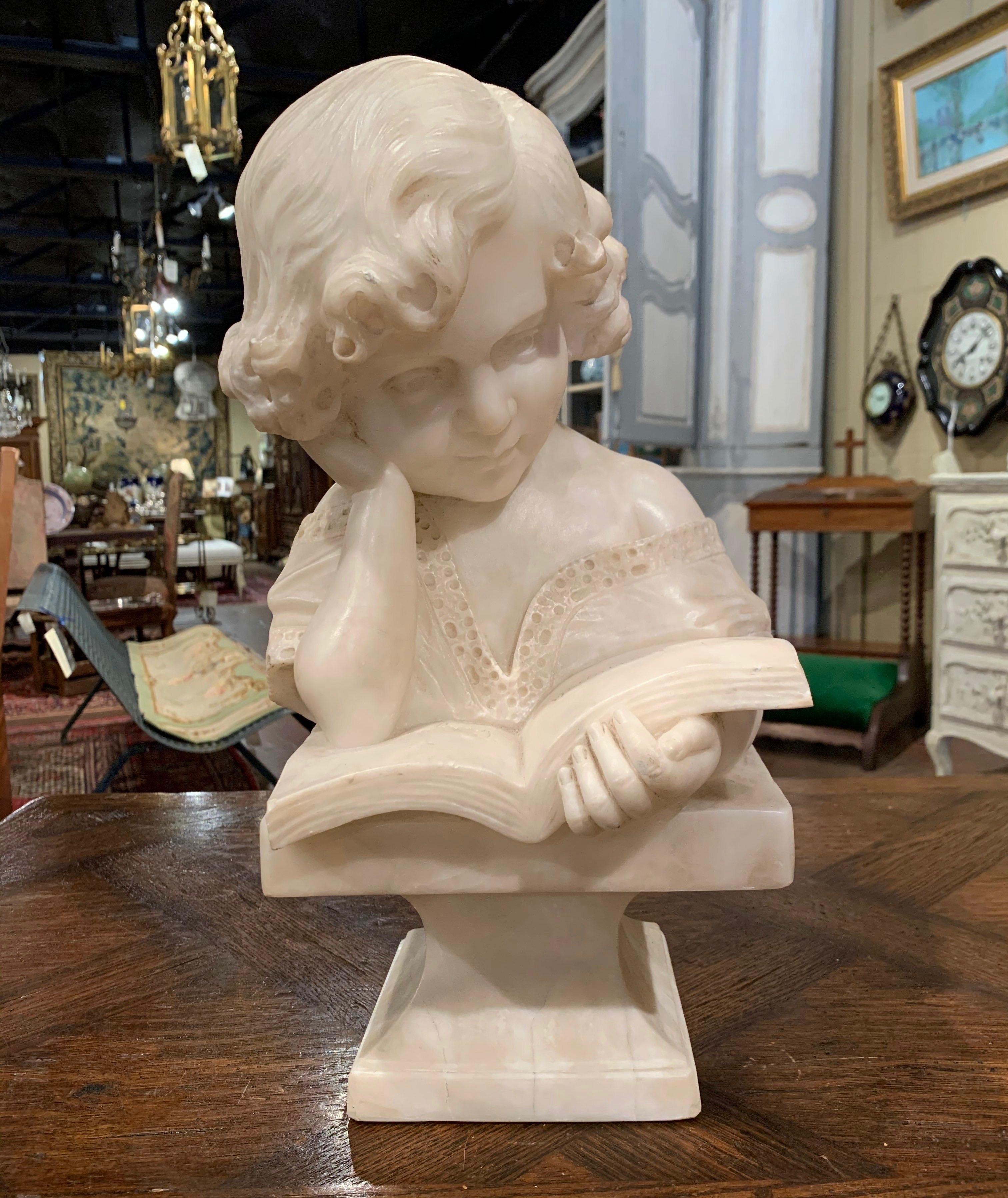 Crafted in Italy circa 1880, the carved bust stands on an attached square base and depicts a young lady reading a book one hand holding her head. The sculpture is well done with wonderful details including the lace collar, her curly hair and her