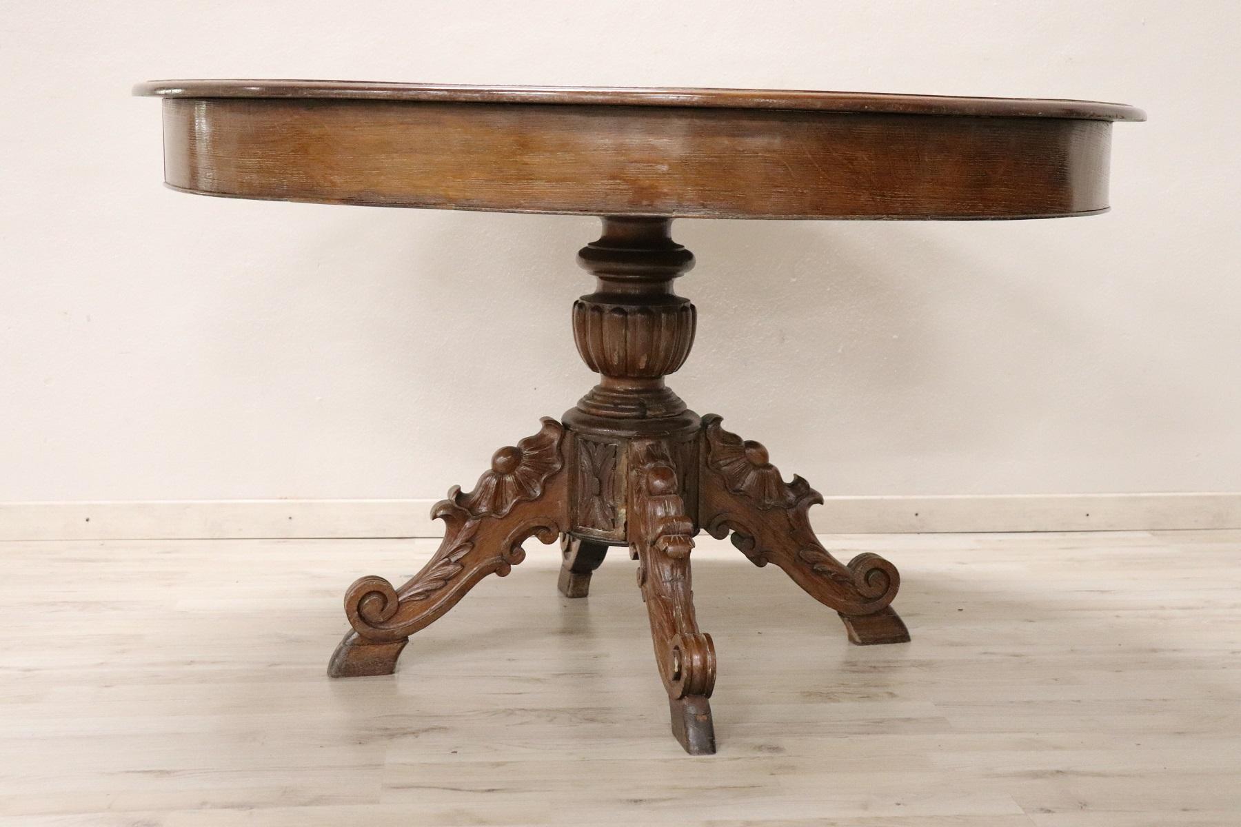 Beautiful important antique round dining room table, 1850s in solid oakwood. This table is perfect for a dining room, it extends into the center becoming a large table that can accommodate many people. The large central pedestal is finely carved in