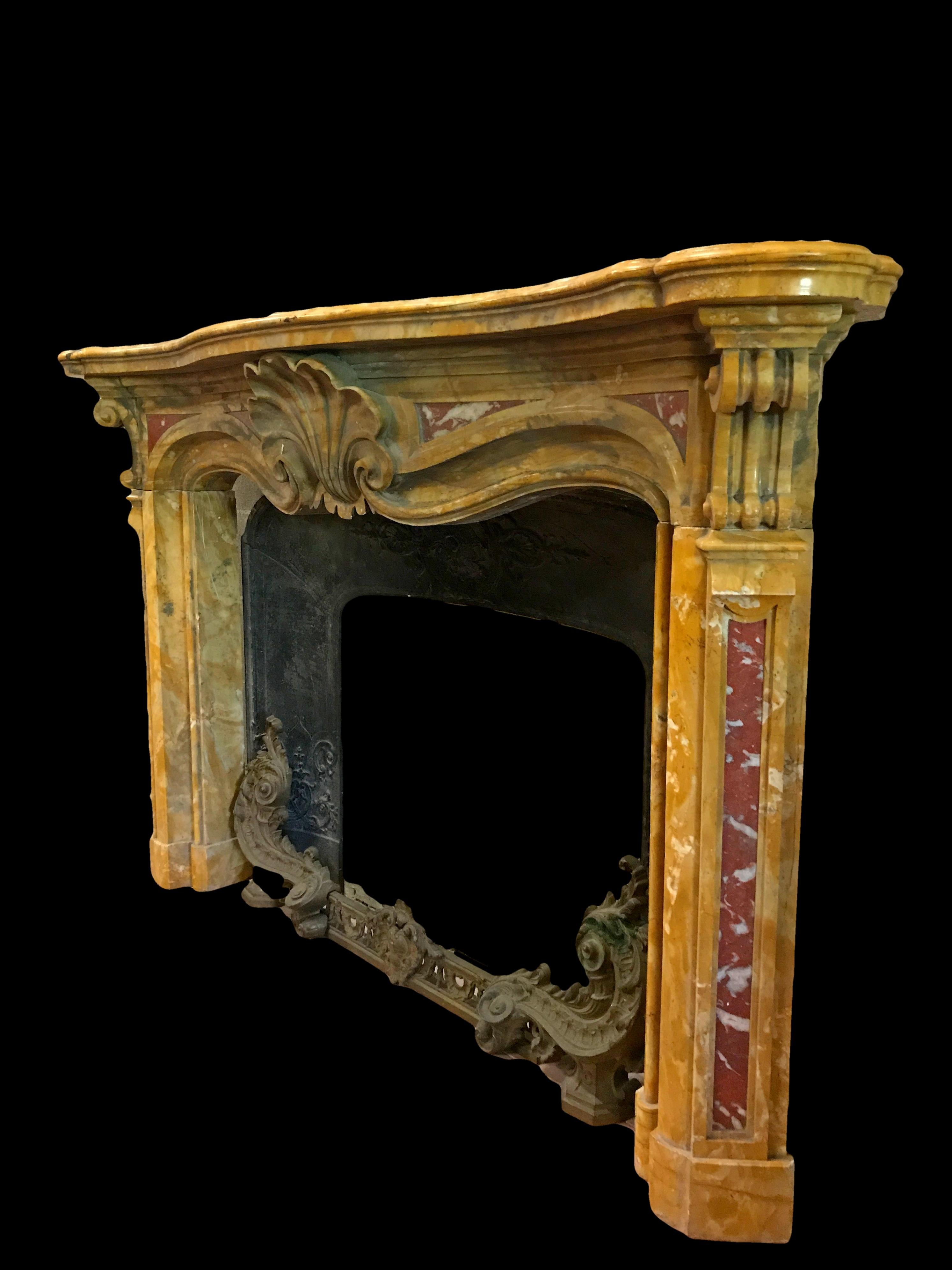 19th century, Italian carved old yellow marble fireplace 

This elegant fireplace was made in the Piedmontese area, north of Italy, in the 19th century in the Louis IV style. The frame of the fireplace is in marble 'old yellow', a rare color that