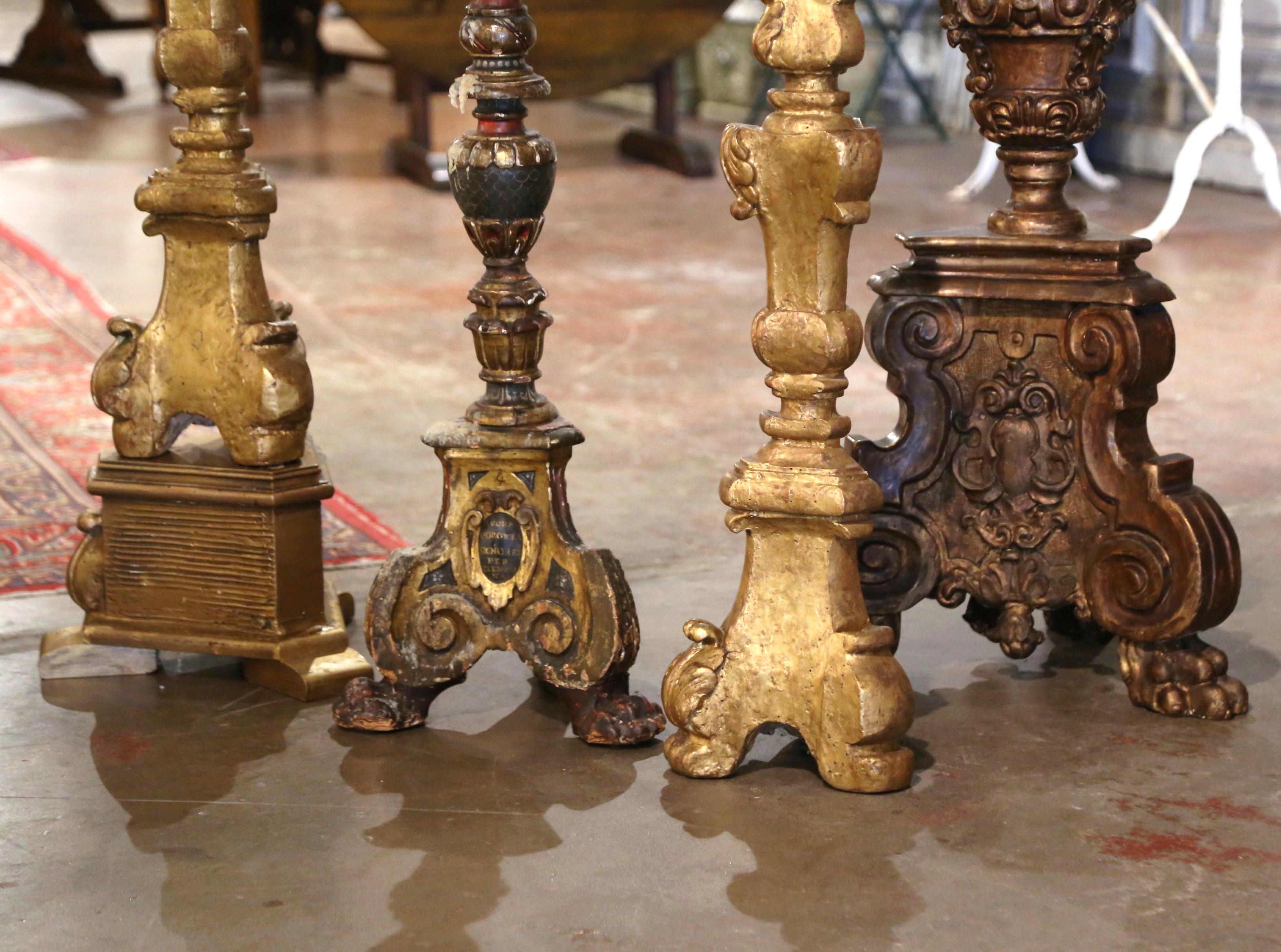Add an air of drama and elegance to your home with this important suite of tall antique candlesticks. Crafted in Italy circa 1860, each candle holder stands on a sturdy triangle base decorated with hand carved angel faces over three paw feet with