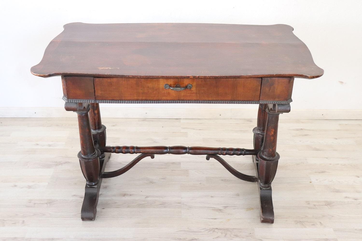 Elegant and essential antique Italian writing desk. The desk is made of solid walnut wood. Important turned and carved legs. Plenty of space for your writing needs and one comfortable large drawer on the front.