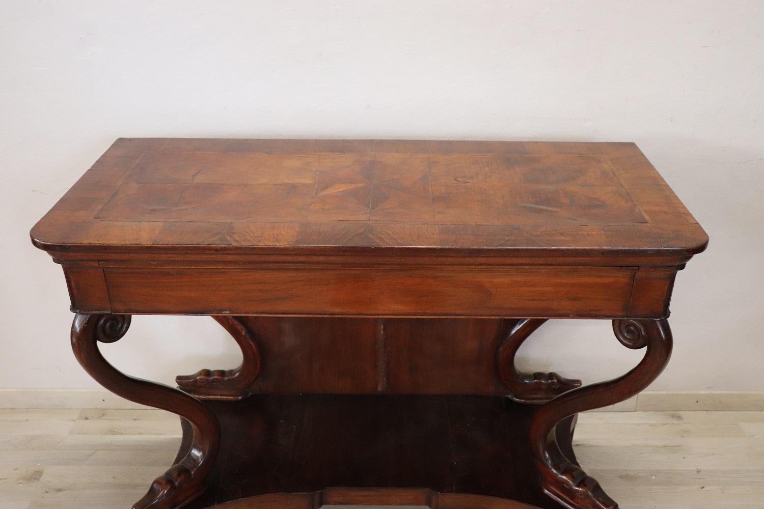Antique console table Charles X 1825s. The console is made of solid carved walnut. On the front a comfortable drawer. The top has a refined inlaid star decoration. The two front decorative legs are moved and have the shape of a triton. Rare due to