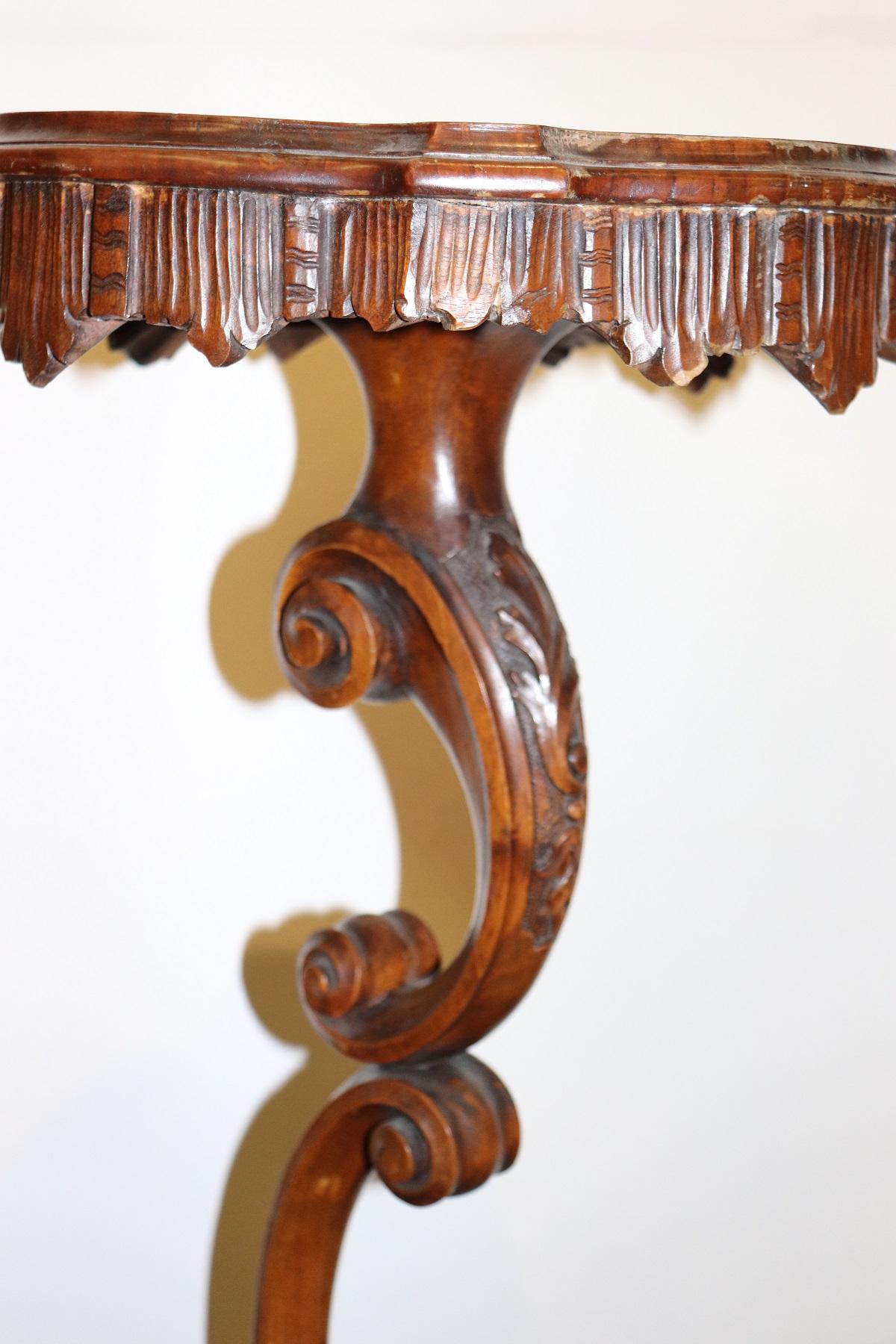 Rare and fine quality Italian gueridon table or pedestal table. The table presents a refined carving work in walnut wood. Look at the curls and the swirls of the stem. The plan has a nice skirt work. Really delicious table. True Italian antiques!