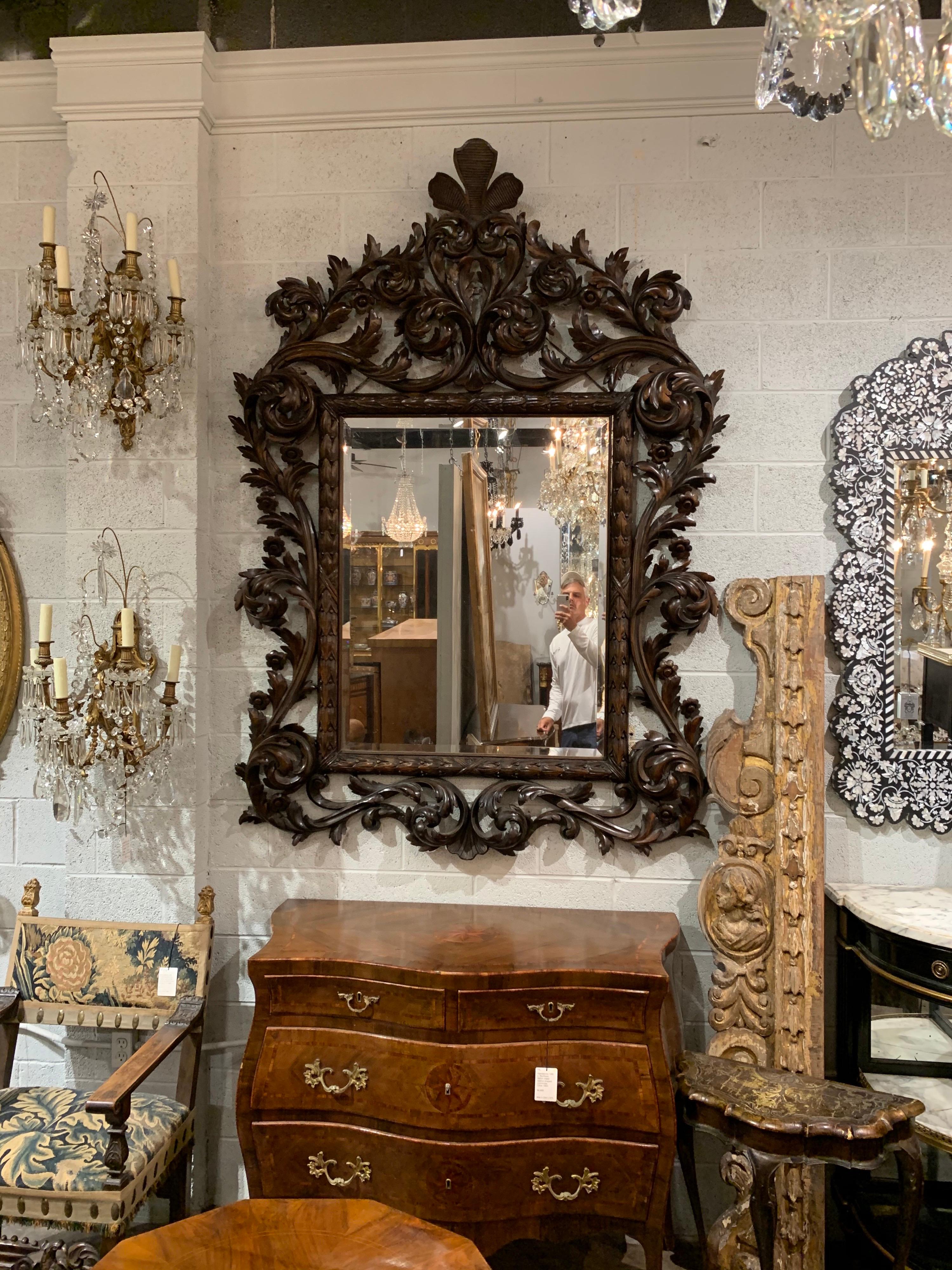 Superb 19th century Italian carved walnut mirror with original beveled glass. Featuring expert detailed carvings. An outstanding piece!