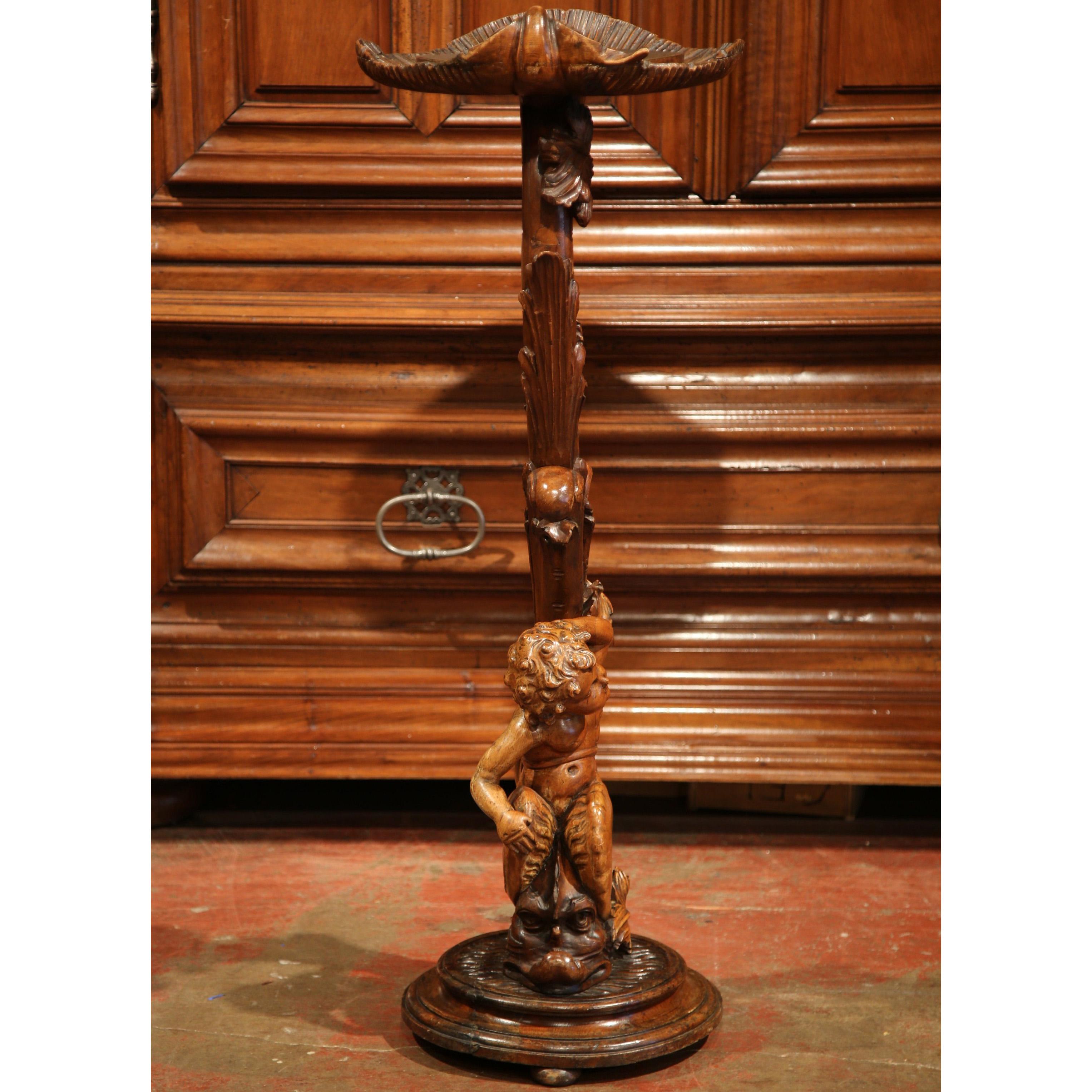 This beautiful, antique fruitwood Selette was crafted in Italy, circa 1860. The carved wooden pedestal stands on a round base and features a scrolled stem in a form of a tree with leaves, and embellished with an expressive cherub at the base sitting