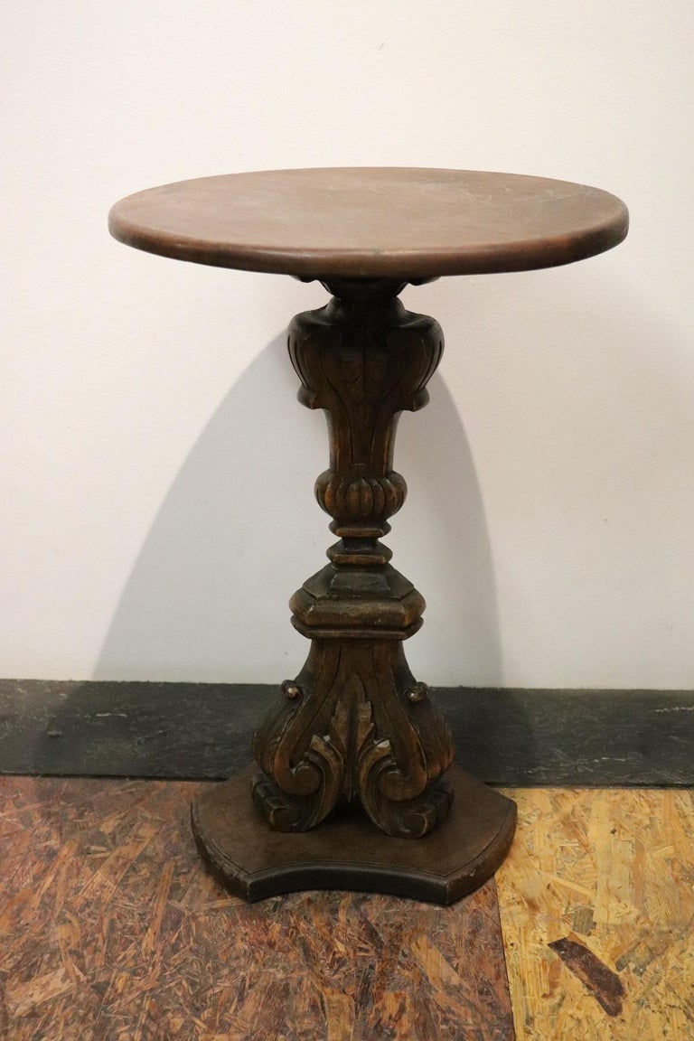Rare and fine quality Italian round side table or pedestal table. The table presents a refined carving work in walnut wood. The table leg is carved only in one side, see the photos. The round top is very convenient to be used in different ways .