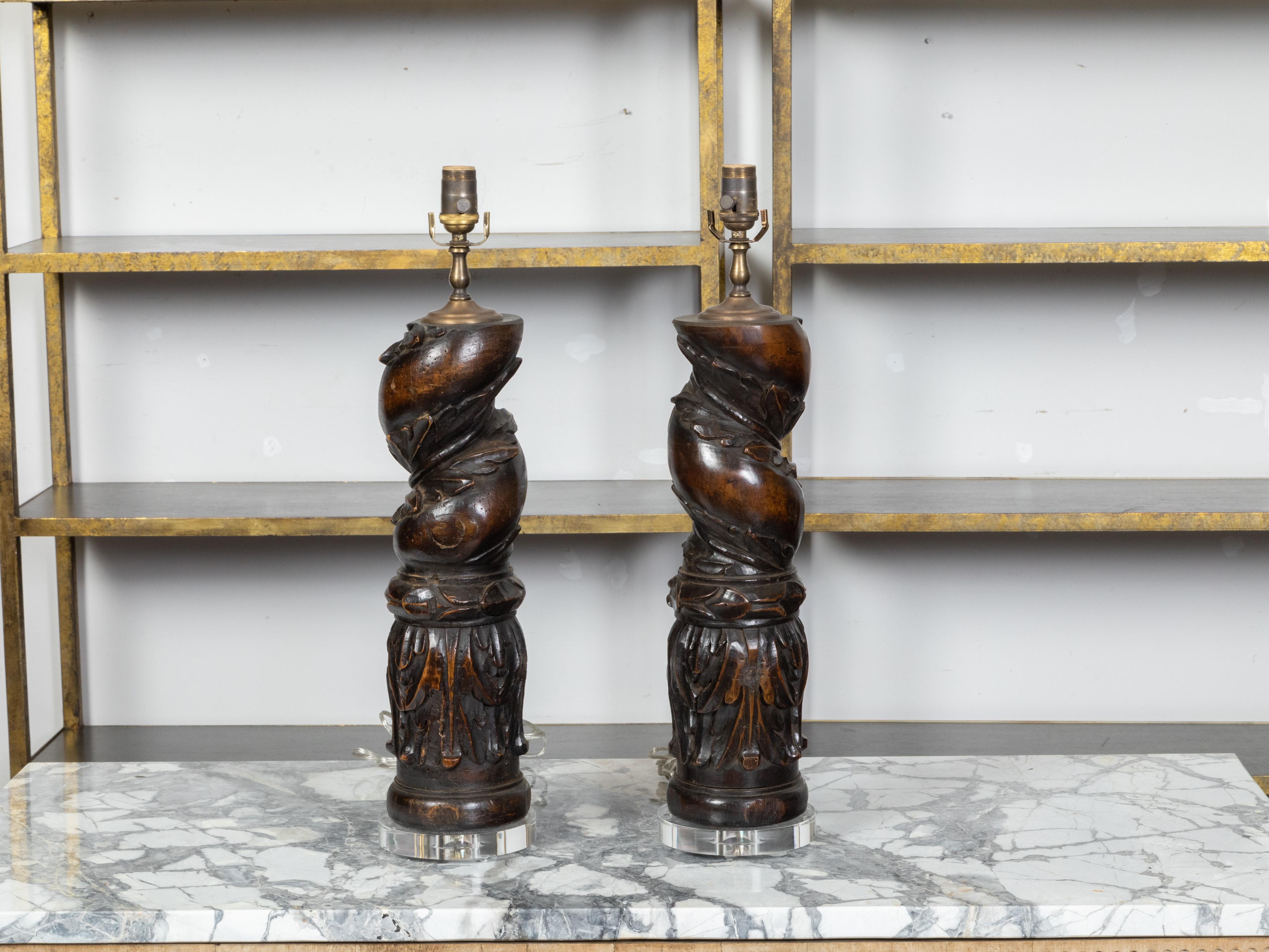 A pair of Italian carved walnut fragments from the 19th century depicting Solomonic columns wrapped with foliage and acanthus leaves, and made into modern US-wired table lamps on lucite bases. Created in Italy during the 19th century, each of this