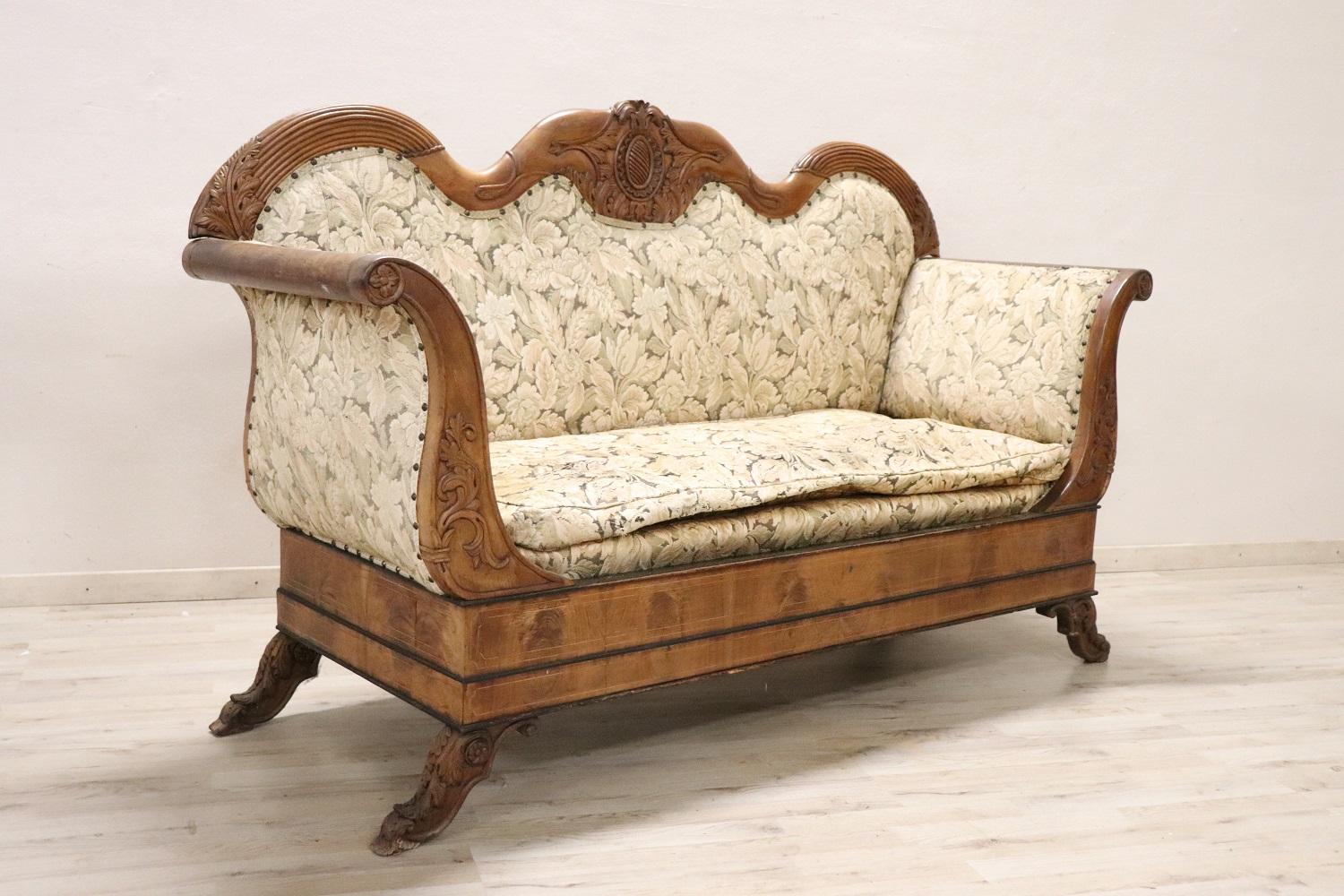 Antique settee 1825s in full Charles X era. The settee is made of solid walnut hand carved. Particular shape called a boat. Large size compared to other antique sofas. Characterized by a refined inlay work in the walnut wood with floral elements and