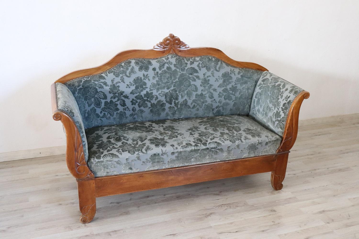 Antique settee 1825s in full Charles X era. The settee is made of solid walnut hand carved. Refined damask fabric in shades of blue. Excellent antique good conditions of the wood and fabric.