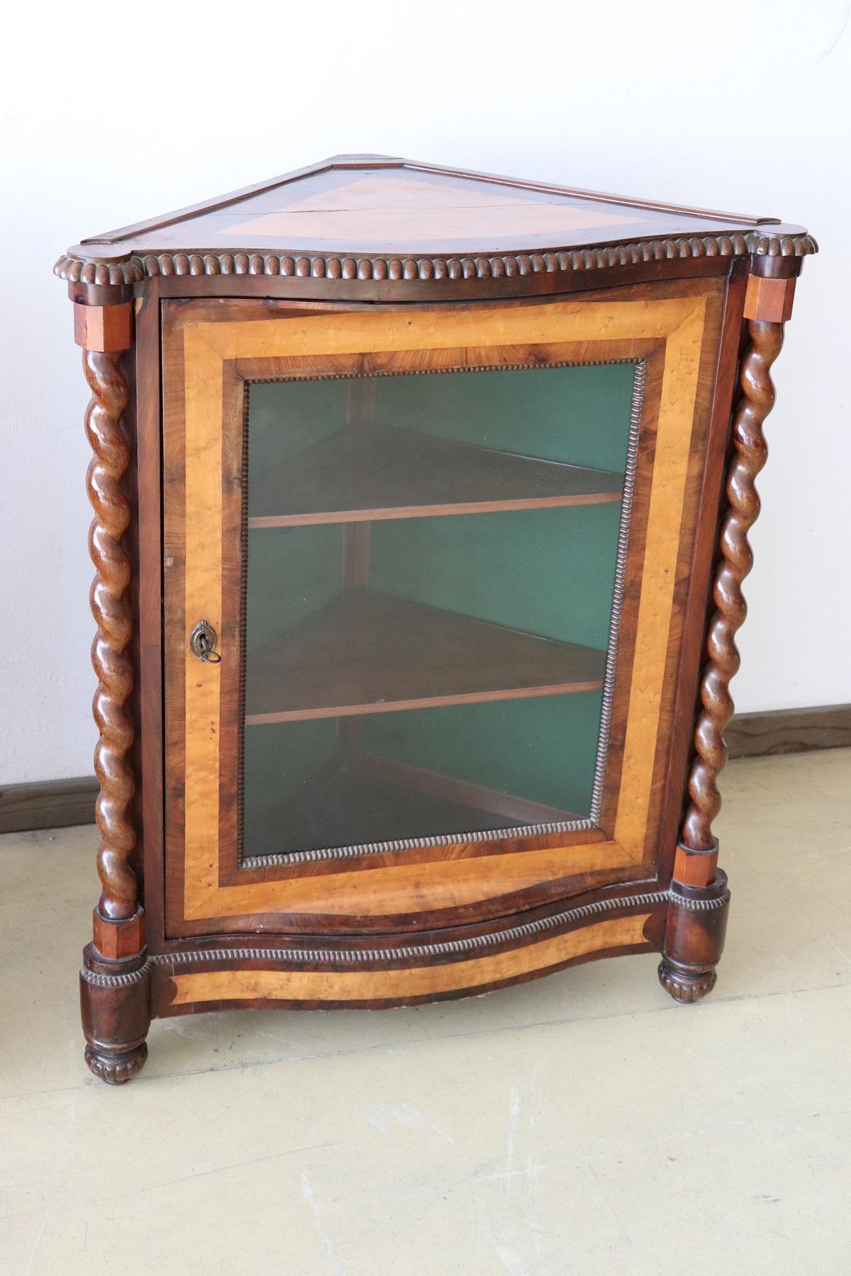 Italian Charles X corner cupboard in precious mahogany wood and birch briar. The back inside is covered in green fabric. On the front two elegant decorative turned columns. Very particular the combination of the color of the two different woods,