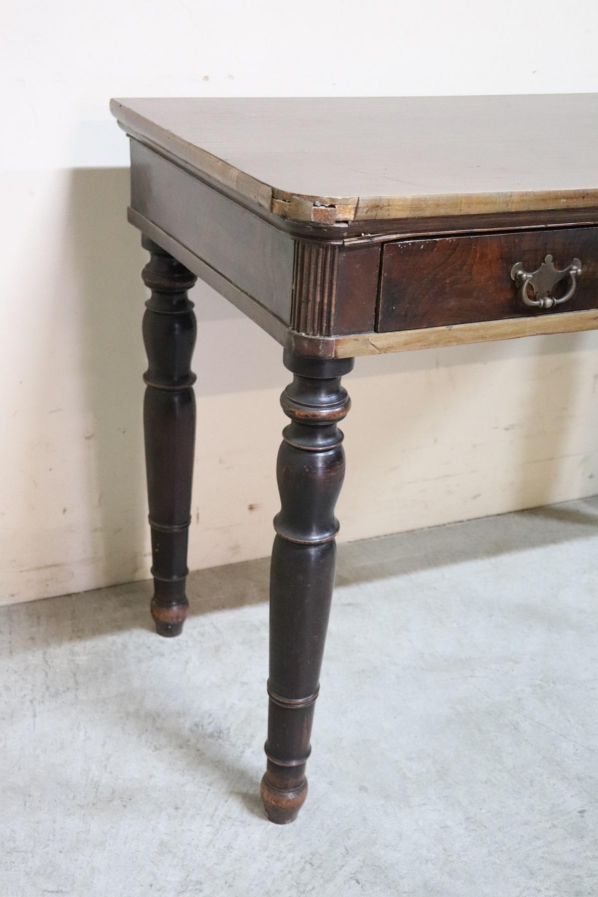 Elegant antique Italian Charles X writing desk. The desk is made of walnut wood. Simple essential line with solid turned legs. Plenty of space for your writing needs and one comfortable large drawers on the front. 
The antique desk has been used in