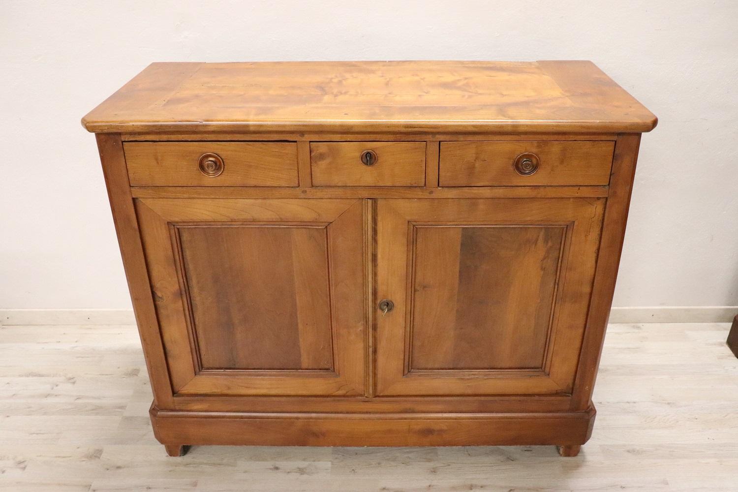 Beautiful sideboard in solid cherry wood made in 1850s. The line is simple and essential, perfect to be placed also in a modern environment. Beautiful patina of cherry wood. Ample useful internal space equipped with three drawers. The sideboard will
