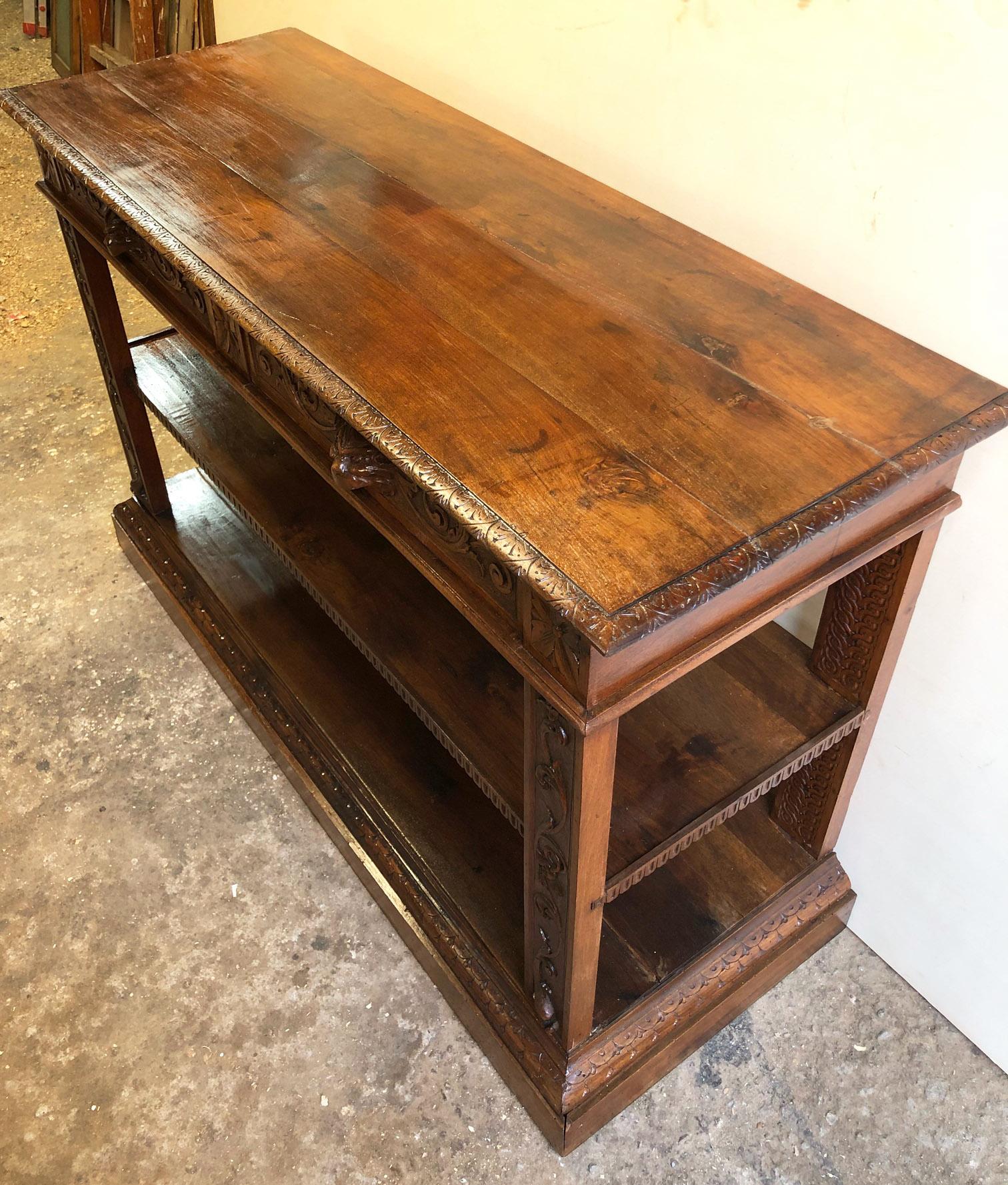 Late 19th century console in hand-carved solid walnut with two drawers in original natural color.
Umbertine style, with intermediate shelf.
The carvings are all done manually.
In ancient times it had a mirror resting on the top.
The handles to open