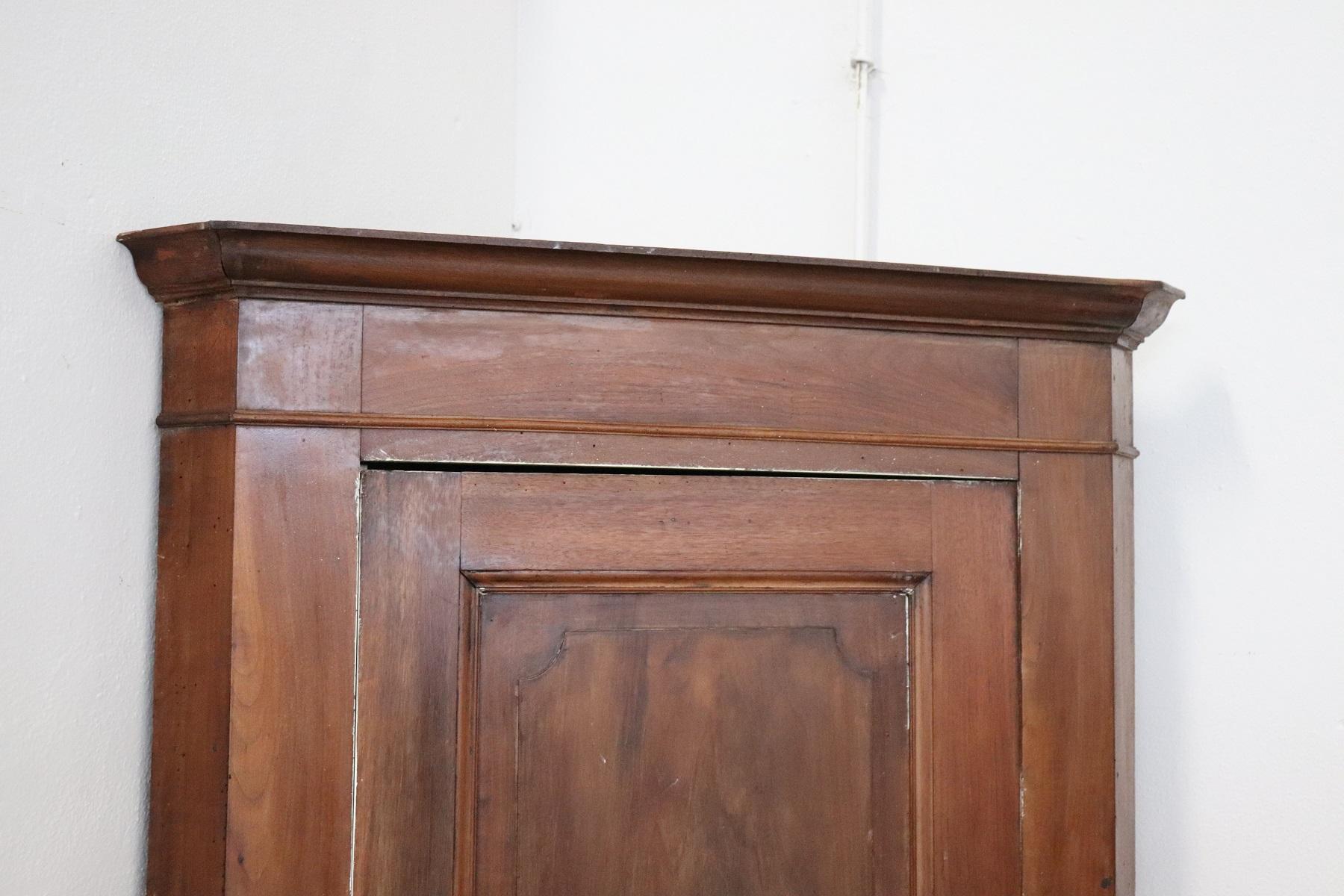 Italian corner cupboard, 1850s. High quality furniture in walnut wood. The front door has a decorative panel. Very simple and perfect for any environment. Internally it had been modified to become a small coat rack but shelves can be made. White