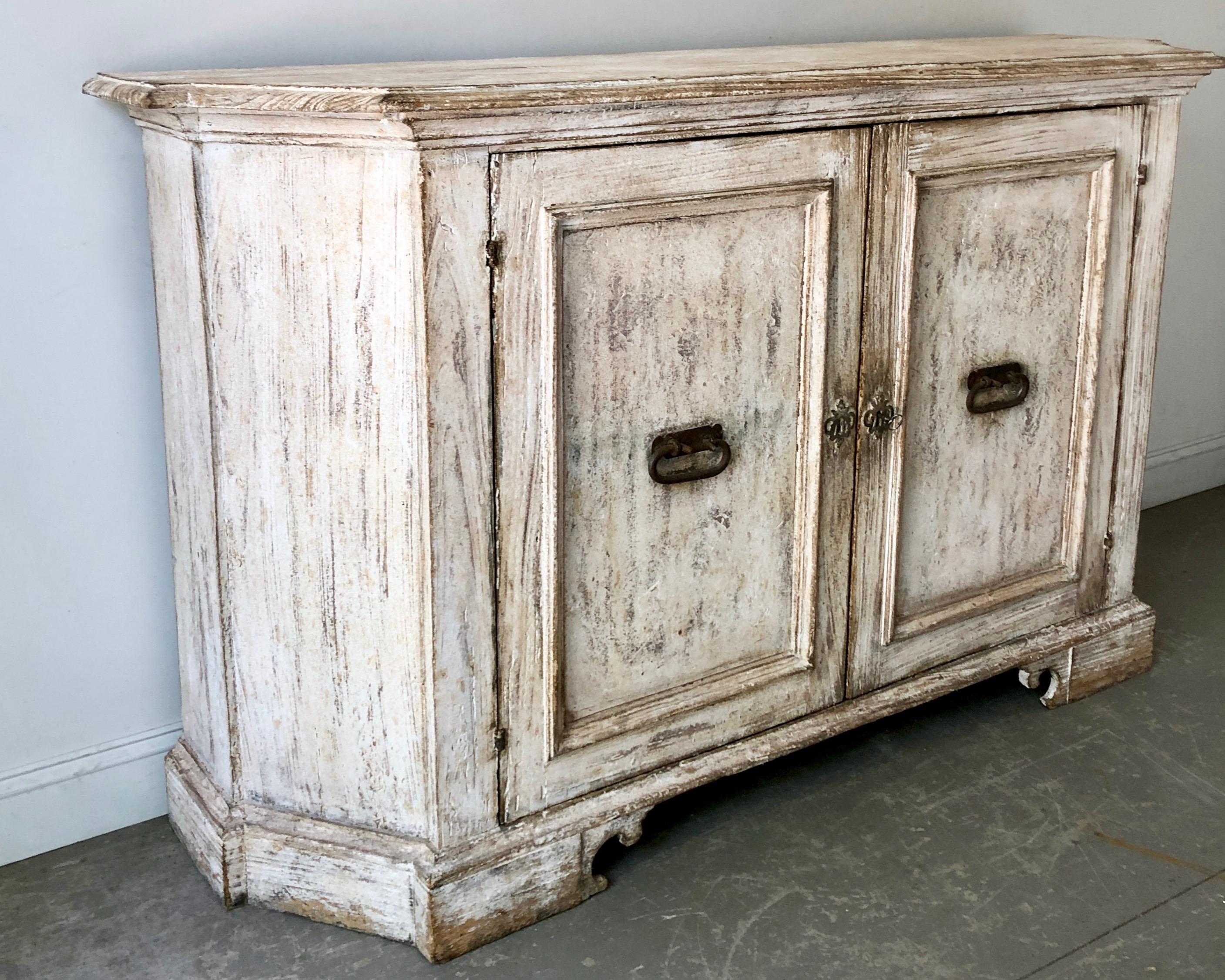 19th century Italian large credenza with thick paneled doors and heavy iron handles, canted corners and shaped top. Later paint.
 