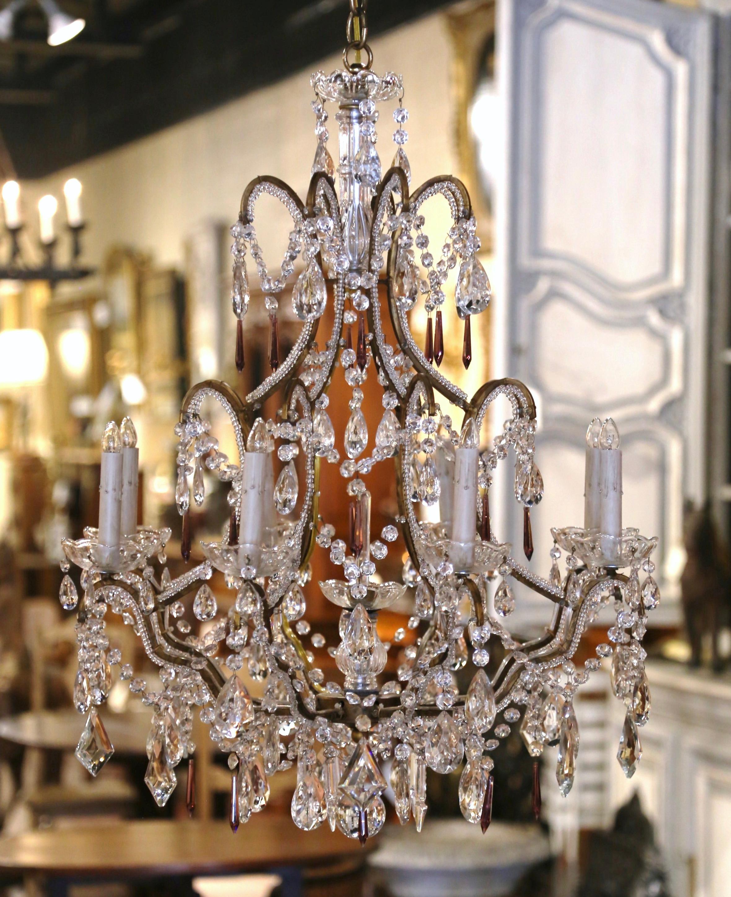 This elegant, antique light fixture was crafted in Italy, circa 1880. The ornate, stately chandelier features eight brass arms with lights embellished with decorative crystal and flower pendants throughout; it is further dressed with decorative