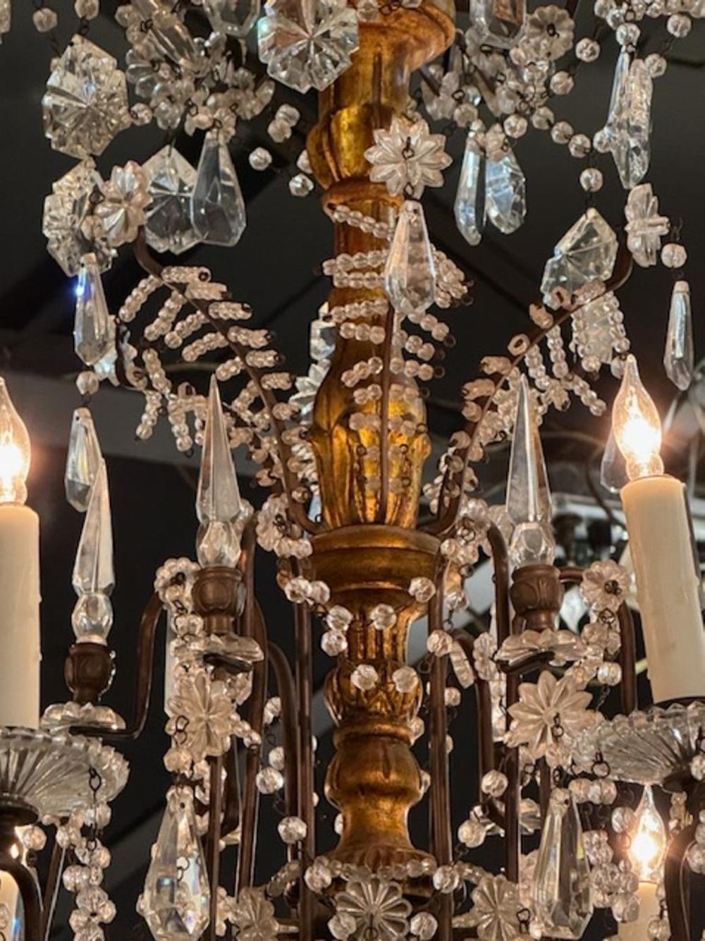 Raffinato lampadario in cristallo italiano del XIX secolo su una base intagliata e dorata. Fa una bellissima figura! Un pezzo di qualità. Questo apparecchio viene fornito con una catena e un baldacchino ed è cablato e pronto per essere appeso.